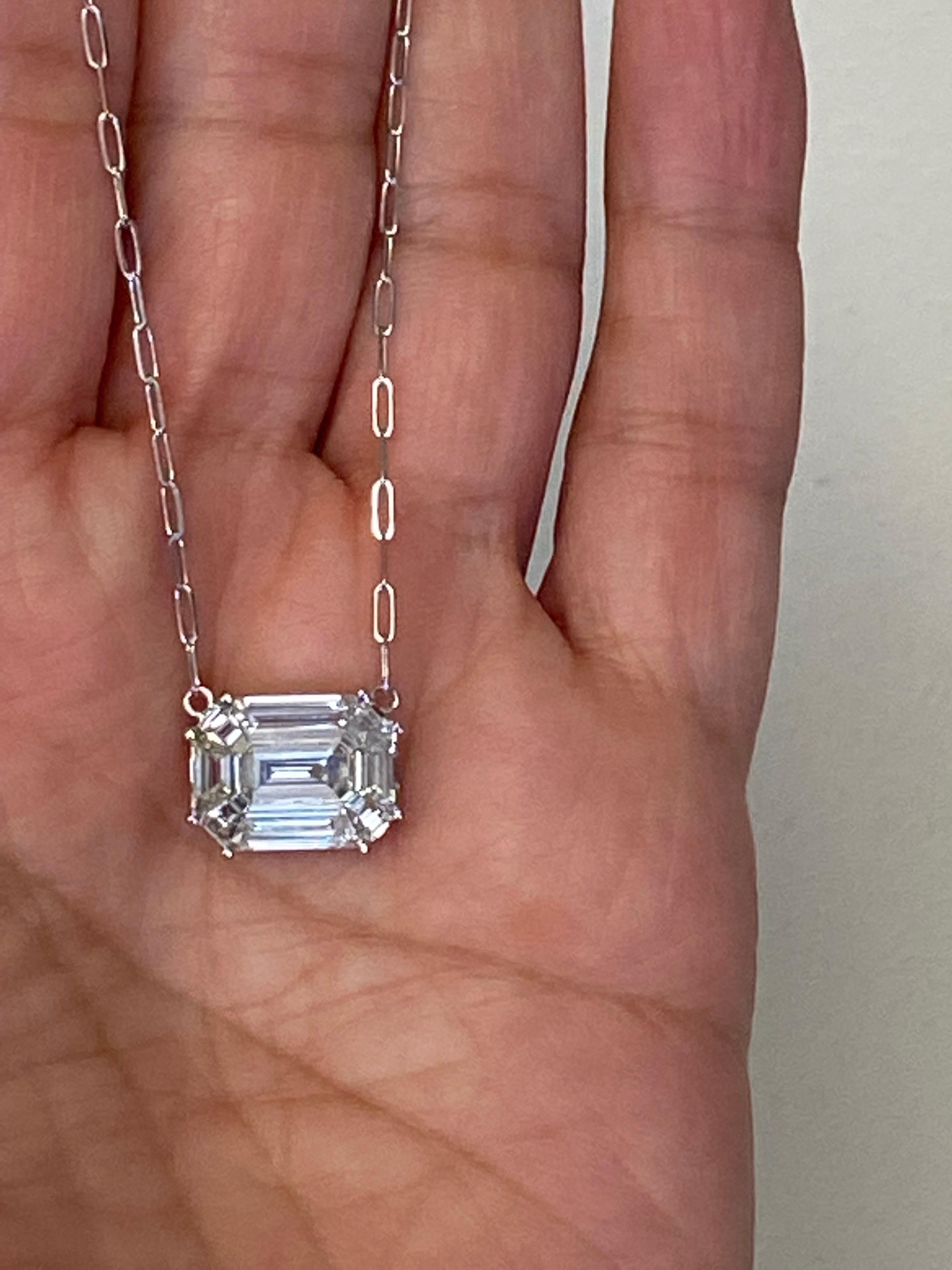 Cluster of baguette, emerald, and trapezoid diamonds set in 18K white gold to create the illusion of a 12 carat emerald cut look. The color of the stones are F, the clarity is VVS1. The total carat weight of the piece is 3.06. This pendant is
