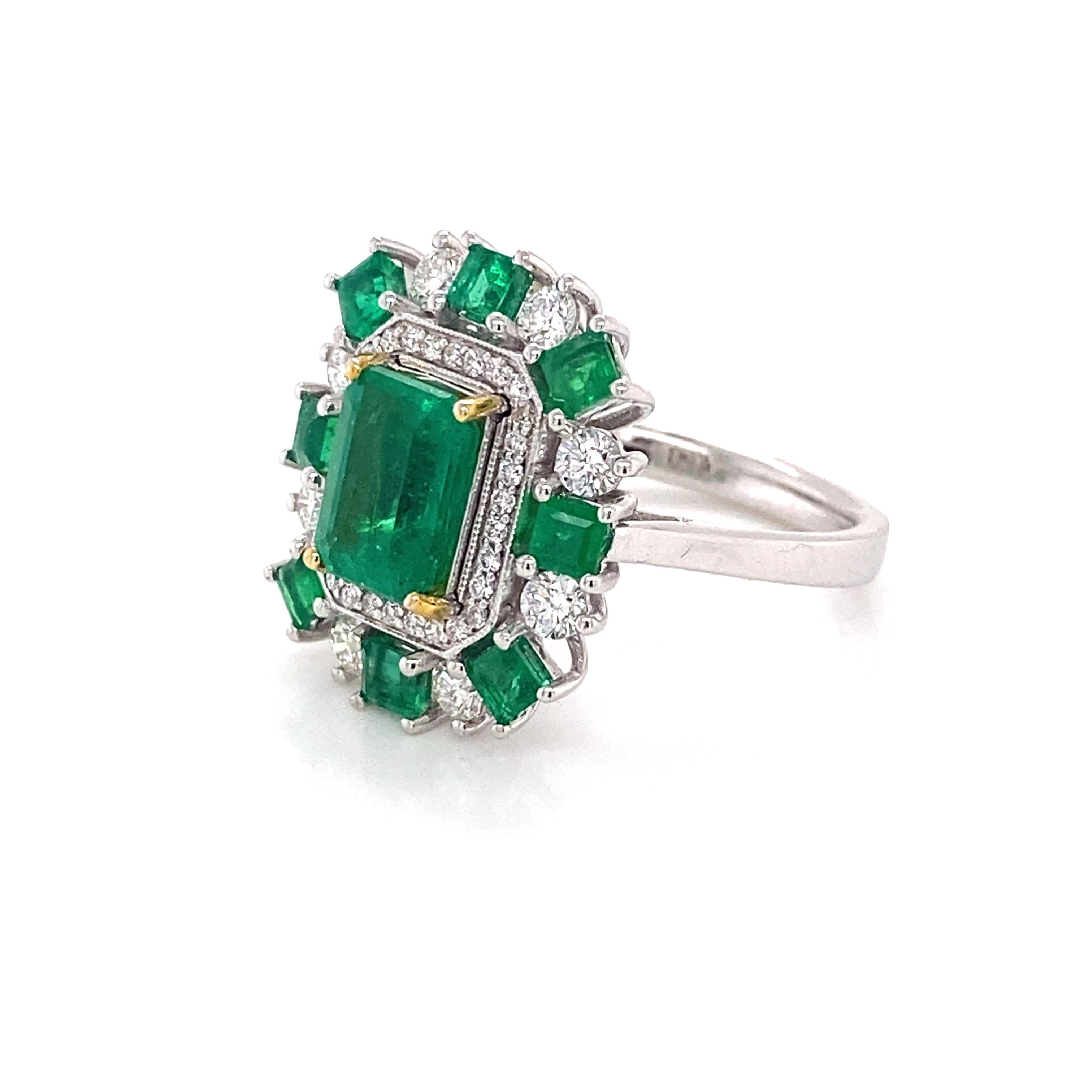 A remarkable setting of emeralds and diamonds set in 18k white gold. The center emerald is emerald cut with an alluring green hue. The additional square cut emeralds are perfectly color matched and together, with the center stone, weigh