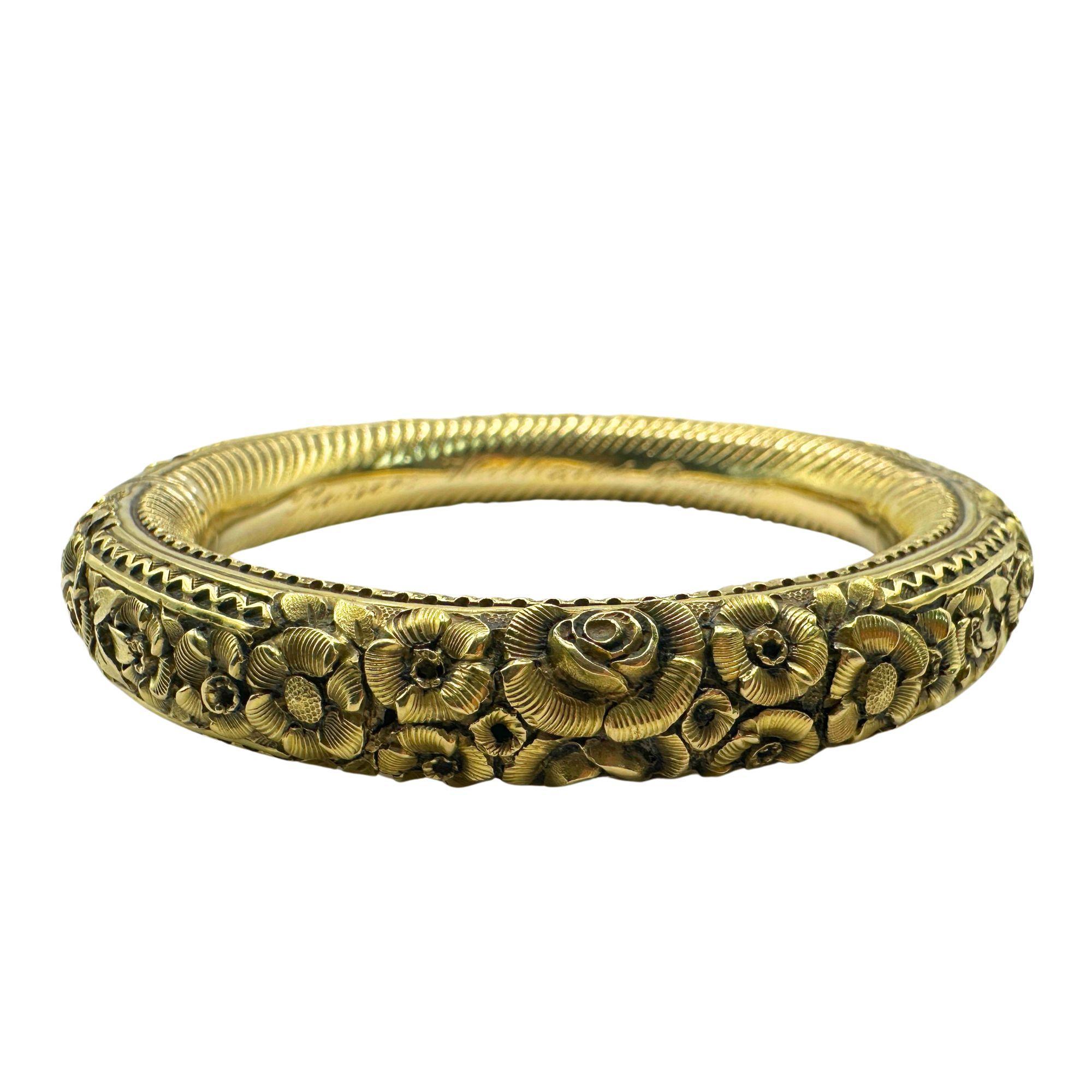 Dieser Armreif aus 18-karätigem Gold hat ein atemberaubendes Blumendesign, das jedem Outfit einen Hauch von Eleganz verleiht. Dieses Nachlassstück ist in gutem Zustand mit geringen Gebrauchsspuren und mit 
