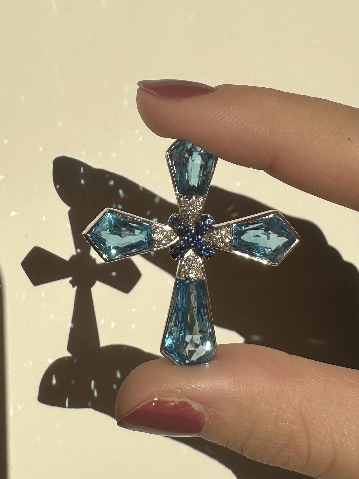 Indulge in a touch of elegance with our 18k Gadi Diamond, Sapphire, and London Blue Topaz Cross Pendant. This stunning estate piece features a total of 2.22 carats of sparkling diamonds, set in 18k white gold. Adorned with a beautiful array of