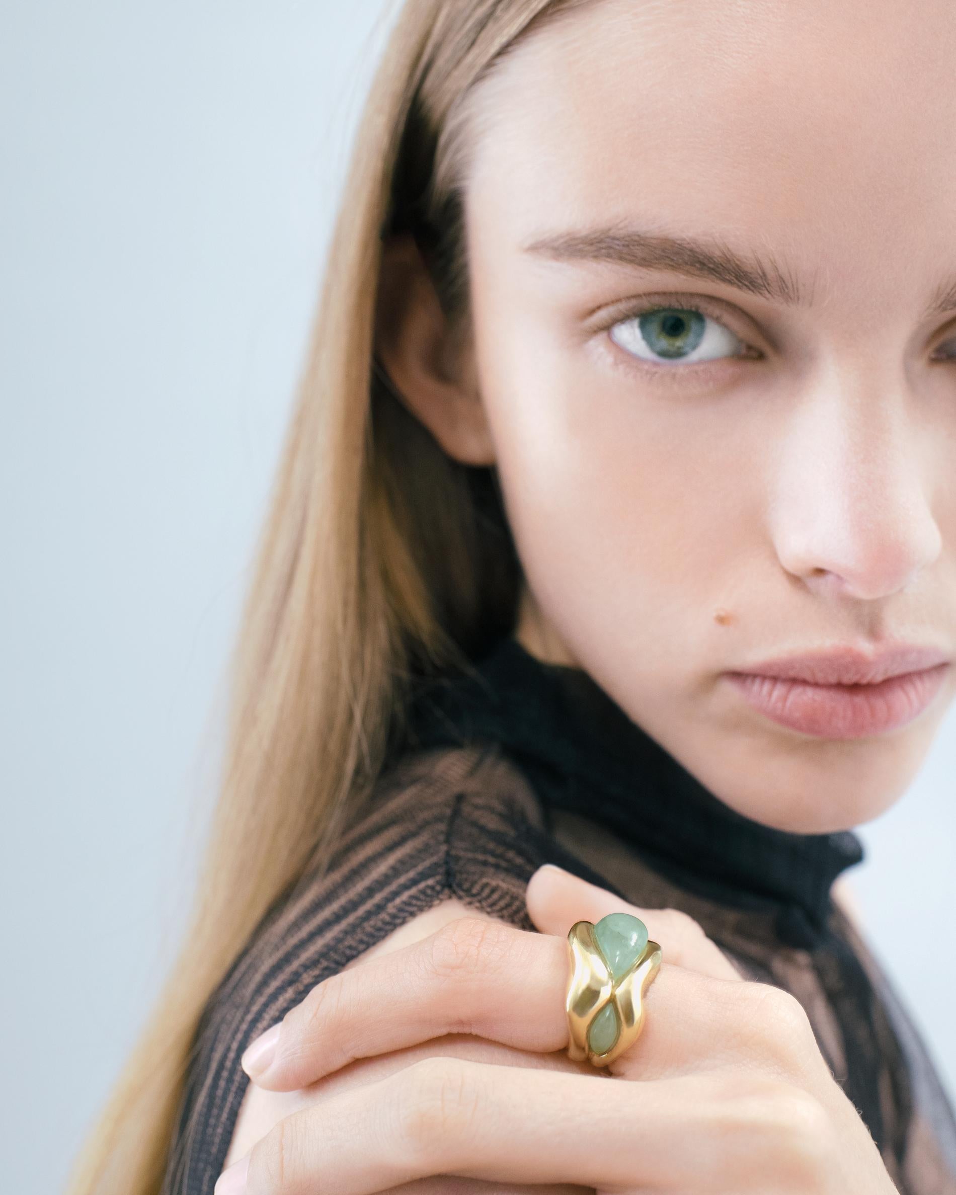 Two stones nestle within the architecture of this ring – two forces held in balance. One sits tight within its setting, while the other appears to emerge, its free and fluid energy creating a beautiful asymmetry. The wave-like form of the whole