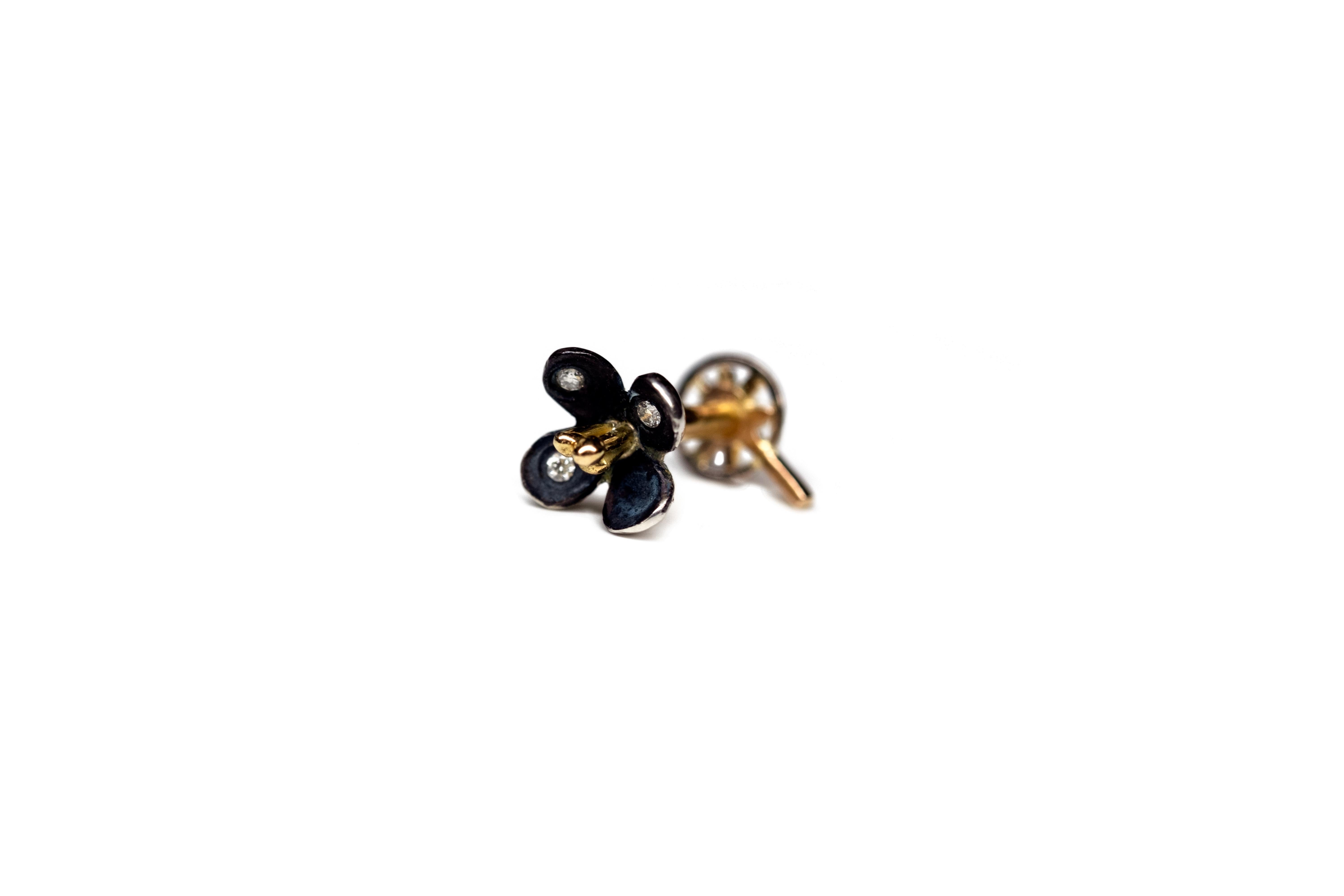 piercing d'oreille en forme de fleur, entièrement réalisé à la main à partir de diamants en or jaune ébénisé 18 carats et d'argent, marque du Canada.

La fleur est vissée dans l'étoile à l'arrière. La vis est fabriquée à la main. Nous vous suggérons