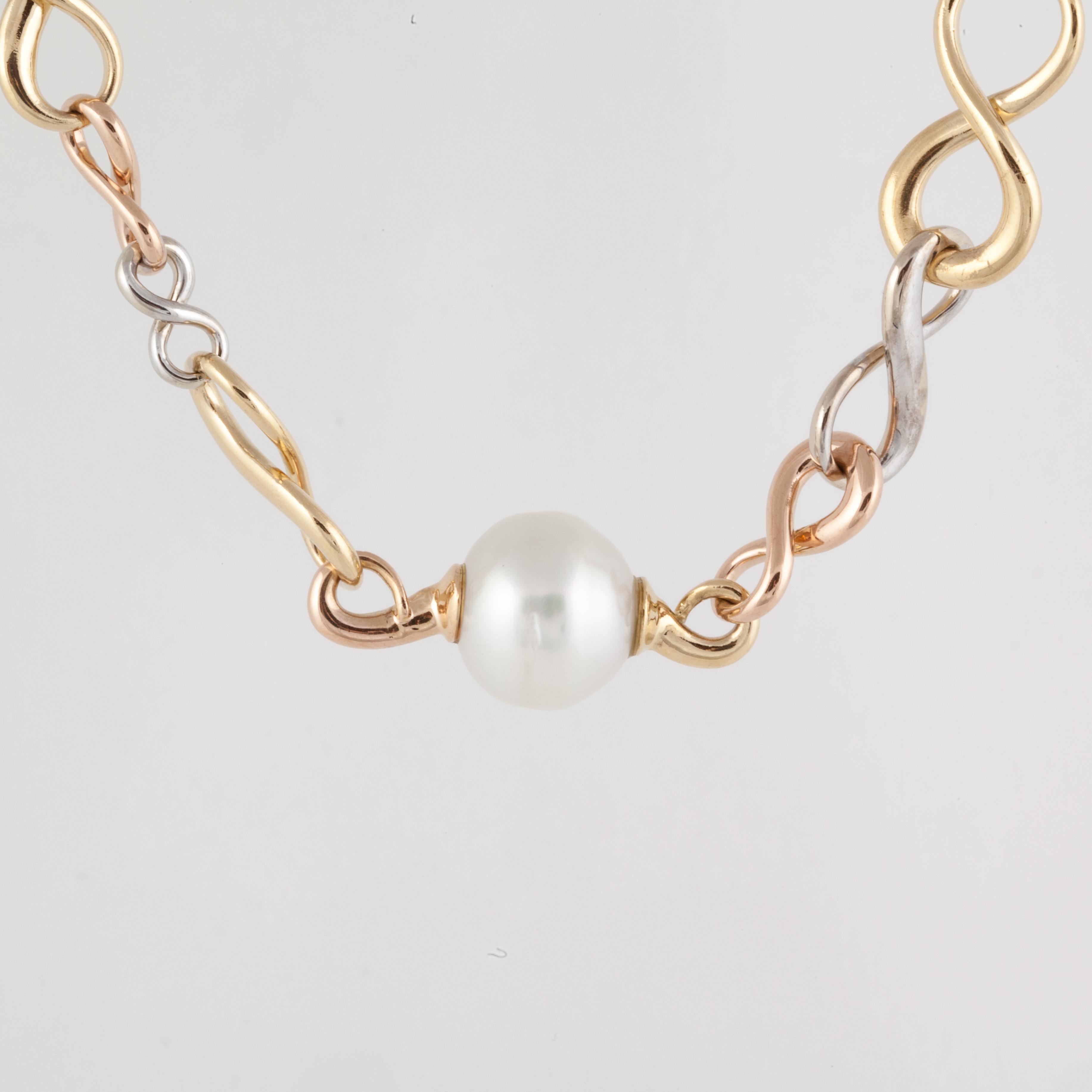 18K trim-color gold figure eight link necklace with three cultured pearls.  The pearls measure 13-14mm.  The necklace is 16 1/4 inches long and 1/2 inch wide.  