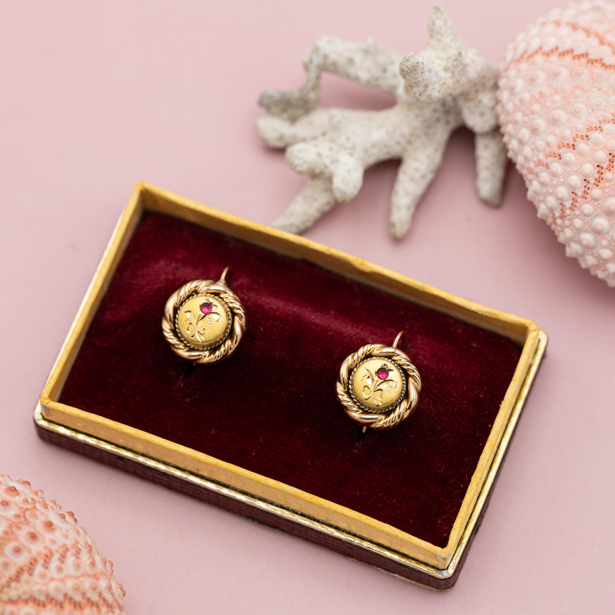 For sale is this wonderful pair of late Victorian 18 Karat yellow gold dormeuse earrings. They are decorated by a twisted boarder and an elegant hand engraved flower. The flower head is set with a small but bright pink none gemstone, which bring the