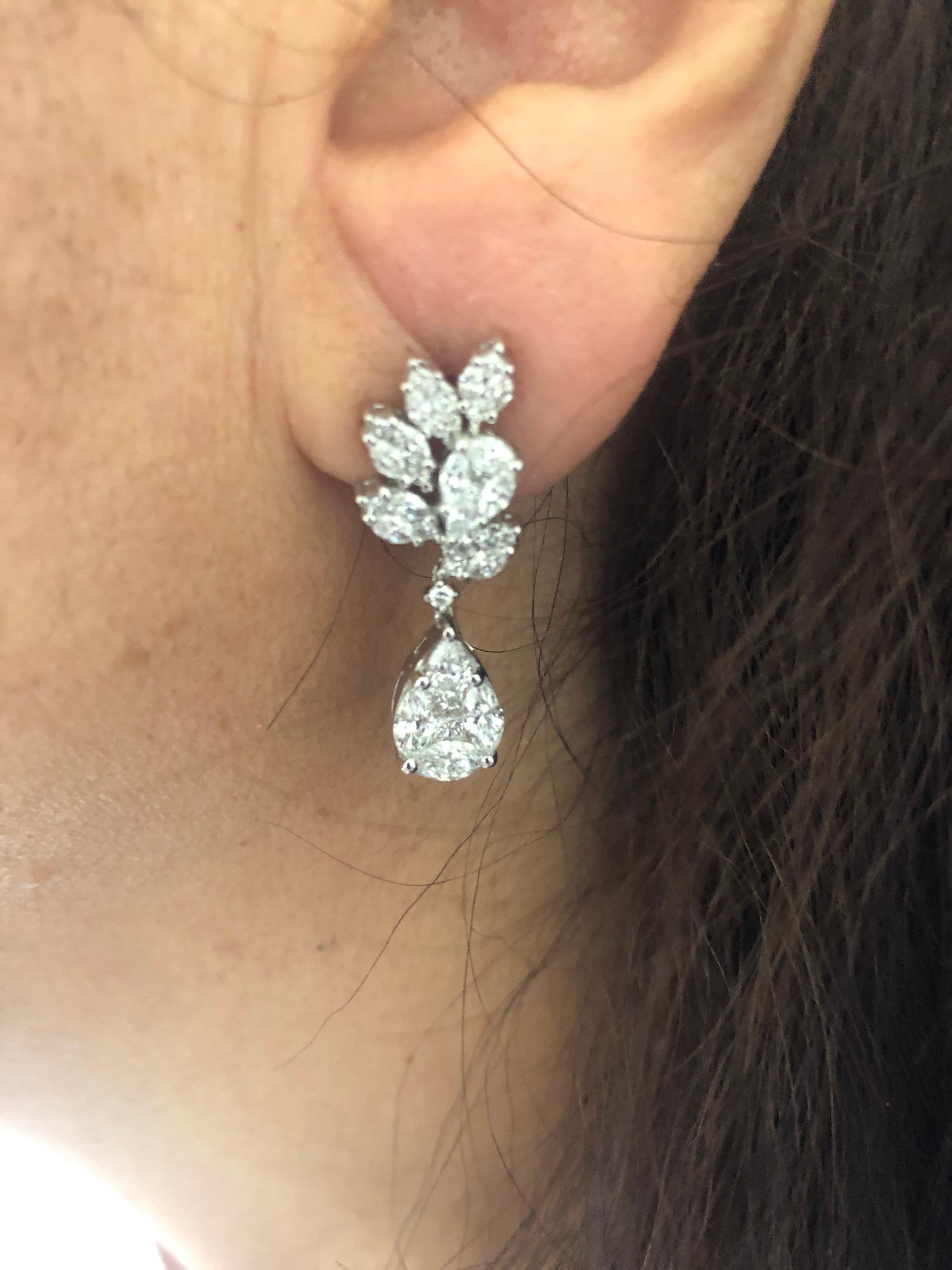 Flower and Pear shaped drop earrings set in 18K white gold. The earrings are cluster of round, princess, and marquise diamonds to create the illusion of a single pear shaped diamond. The total carat weight is 3.37. The color of the stones are F, the