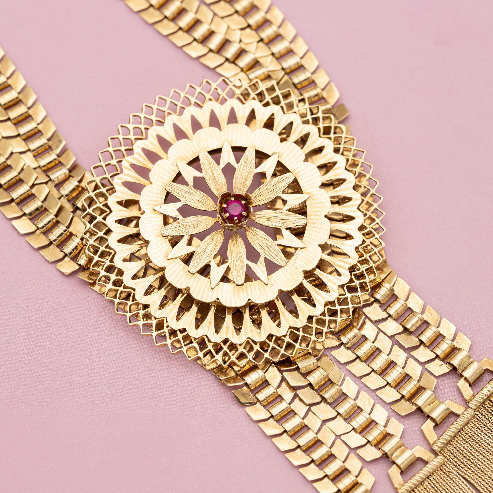 Nous vous proposons ce magnifique collier français des années 1940 (ca. 1942). Ce collier grandiose est réalisé en or jaune massif 18 carats et serti de trois belles pierres précieuses naturelles rose foncé (saphir). Le grand pendentif floral et les