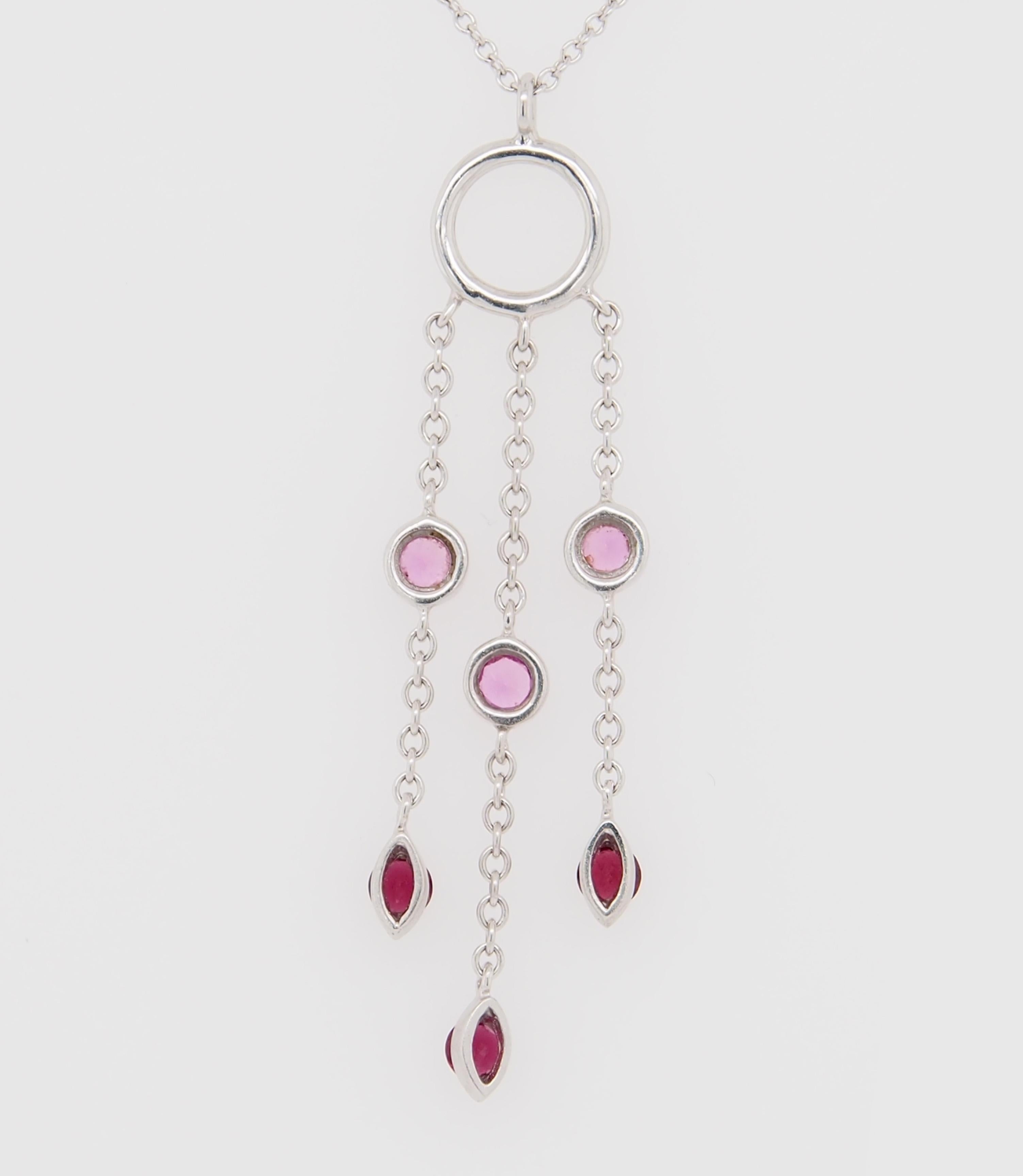 A Tiffany and Co 18K white gold fringe dangle Necklace. (3) Round Pink Sapphires and (3) Round Red Garnet Dangle from a ring. The necklace is 16 inches long, the fringe is 1 1/4 inches. Weighs 3.7 grams.

