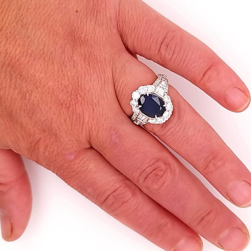 A Oval Sapphire and Diamond Ring in 18K White Gold.  The center is GIA certified 2.70 carat Natural Blue Oval Sapphire set in a 1.84 carat total weight Round Brilliant Cut and Baguette Diamond setting.  The diamonds are G-H in color and VS-SI in