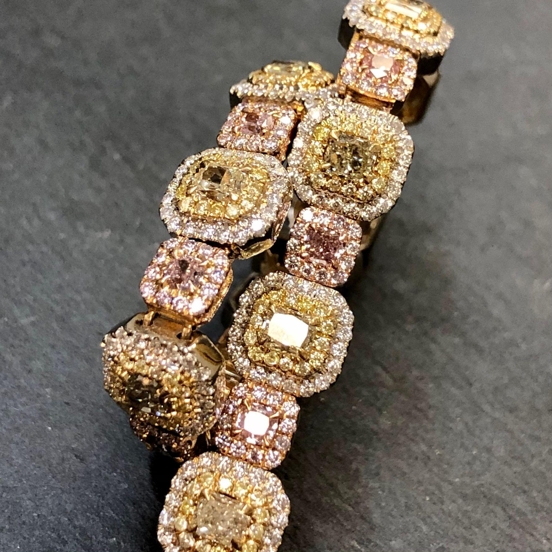 An incredible fancy colored diamond bracelet done in 18K yellow, white and pink gold set with numerous fancy colored diamonds with a total known weight of 8.28cttw. The exact breakdown is below:
Yellow Cushions - 13 Stones - 3.53cttw
Pink Cushions -