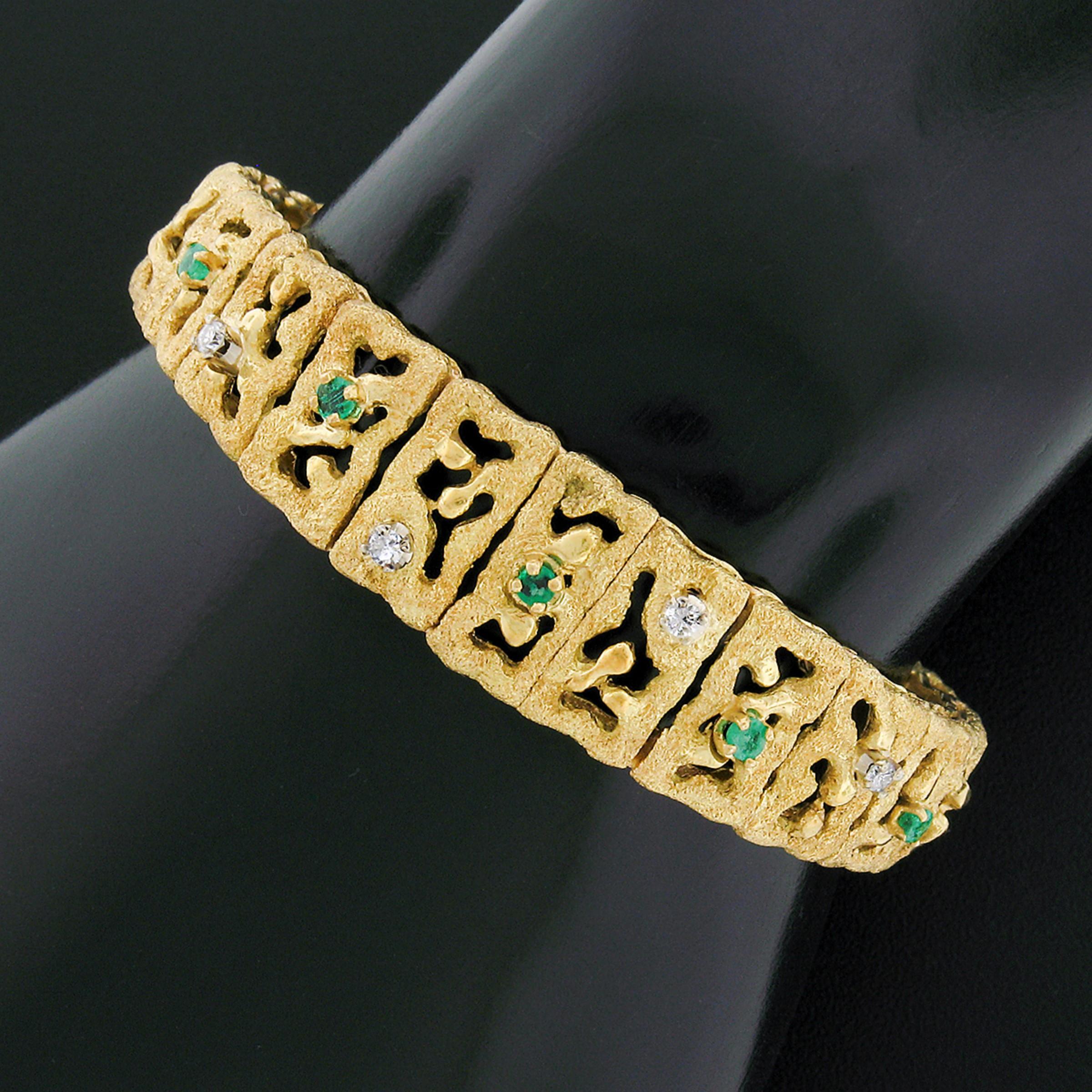 This beautiful statement strap bracelet was crafted in Italy from solid 18k yellow gold and features fine diamonds and emeralds neatly prong set throughout the center of a unique design. The bracelet displays a wonderful textured finish with open
