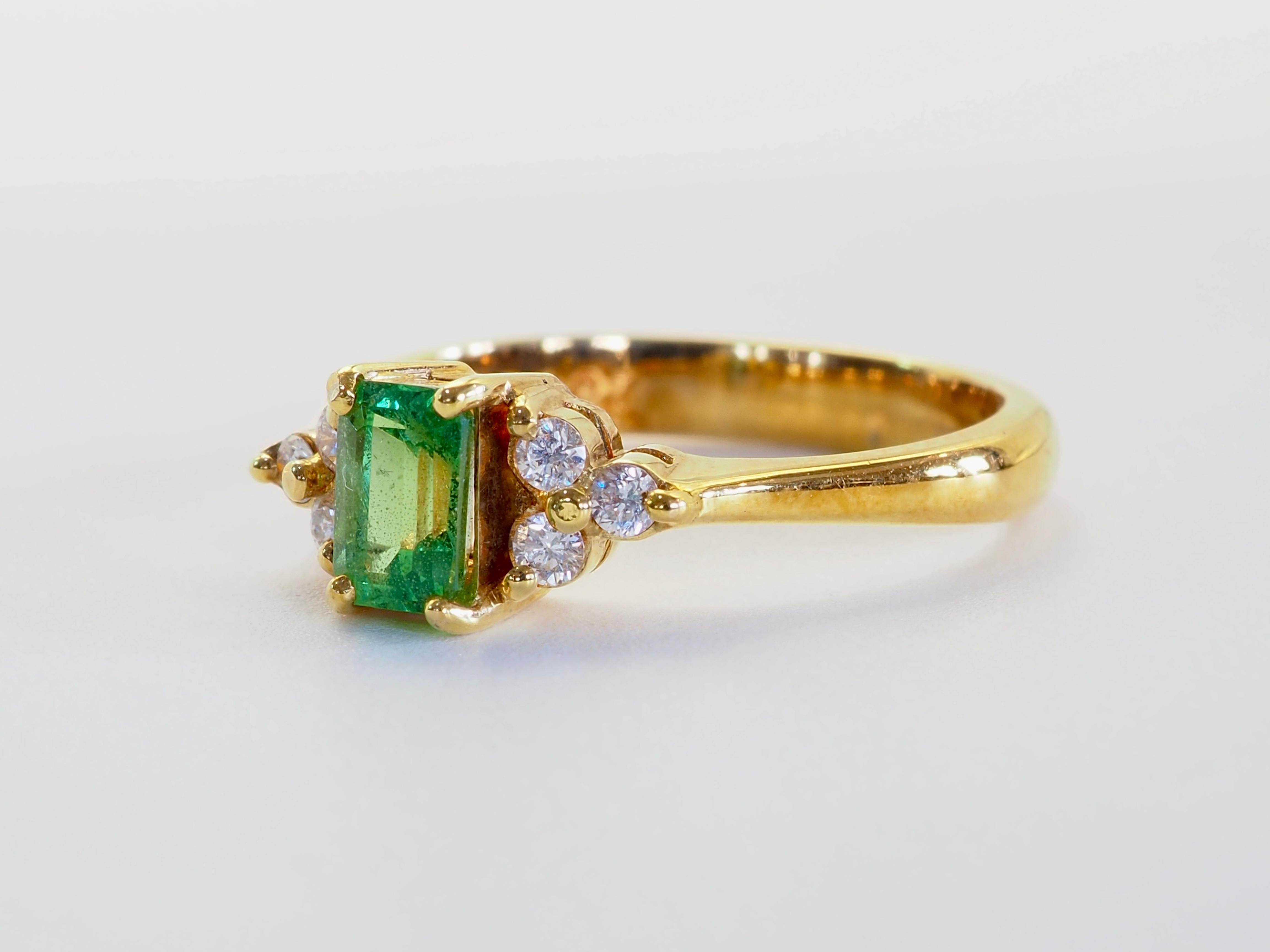 Célébration éclatante de la couleur et de l'artisanat, cette élégante bague est ornée d'un brillant grenat tsavorite de 0,70 carat de taille émeraude, prisé pour sa teinte verte luxuriante et sa brillance exceptionnelle. Flanqué de part et d'autre