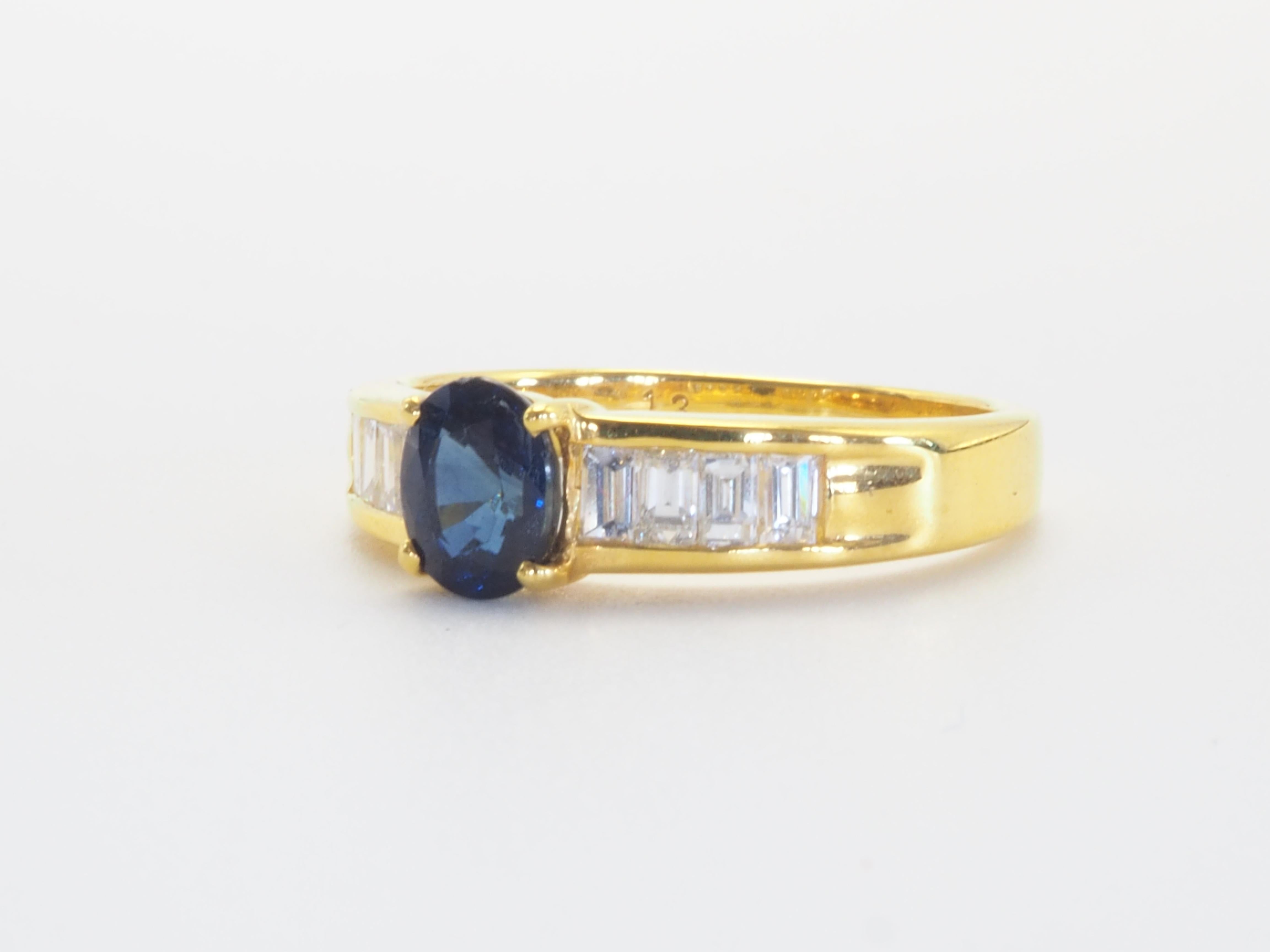 This beautiful engagement band ring boasts a fine oval blue sapphire! The sapphire is an oval cut and is very clear with slight natural inclusions and the deeper color tone akin to ink blue but slightly lighter than. There are 8 big baguette
