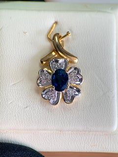 Colgante floral de oro de 18 quilates con un zafiro azul ovalado de 0,95 ct y un diamante de 0,08 ct