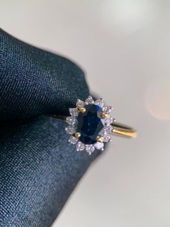 Bague « Sunburst » en or 18 carats, sertie d'un saphir bleu ovale de 1,07 ct et d'un halo de diamants de 0,20 ct