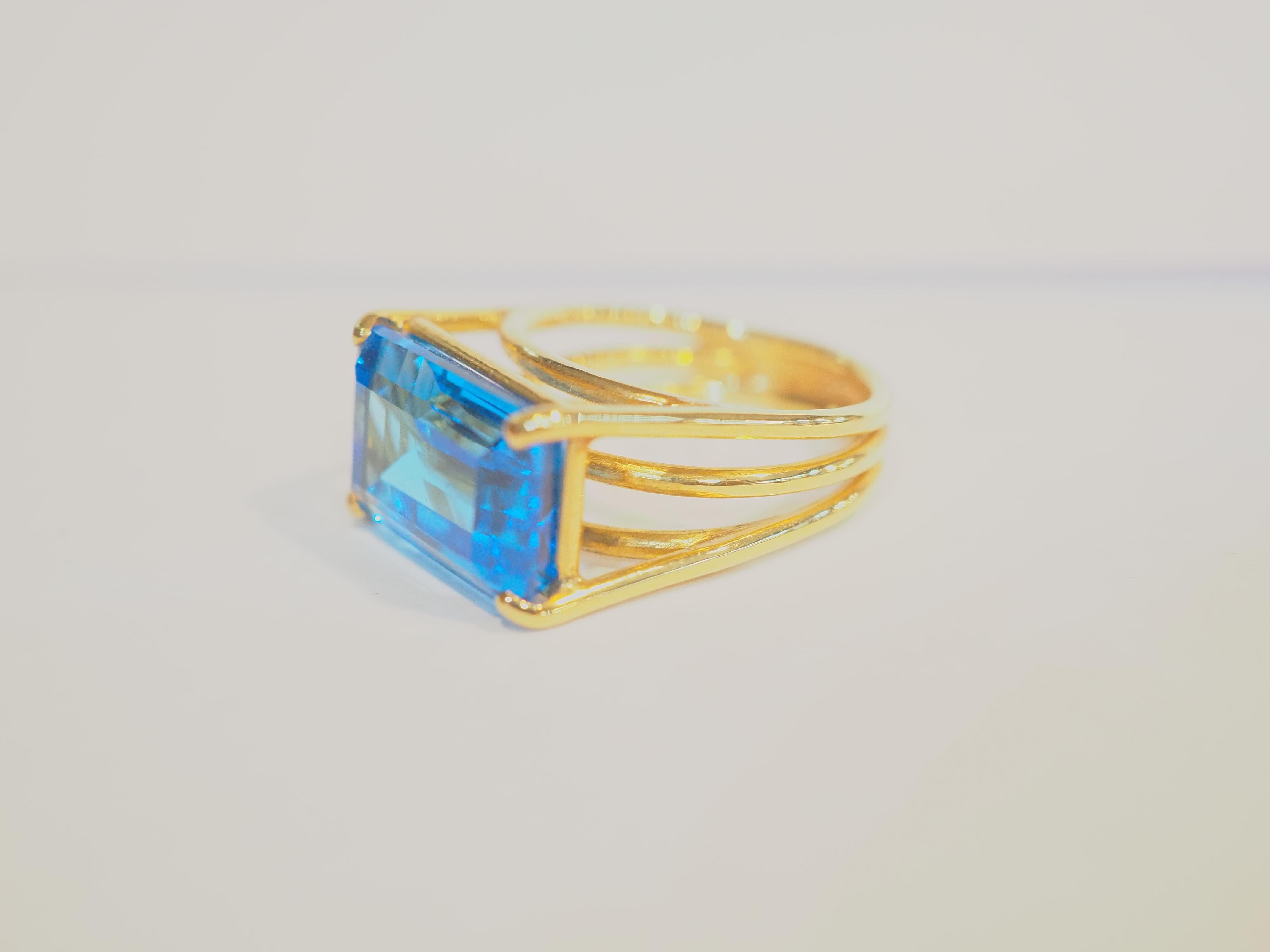  This beautiful cocktail ring boasts a spectacular and good quality rectangular cut blue topaz! The blue color saturation for this gemstone in particular is amazing with richer blue color. The design of the ring features three bands overlapping one