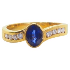 Anello a fascia ondulata in oro 18 carati con zaffiro blu ardente ovale da 1,10 carati e diamante da 0,14 carati