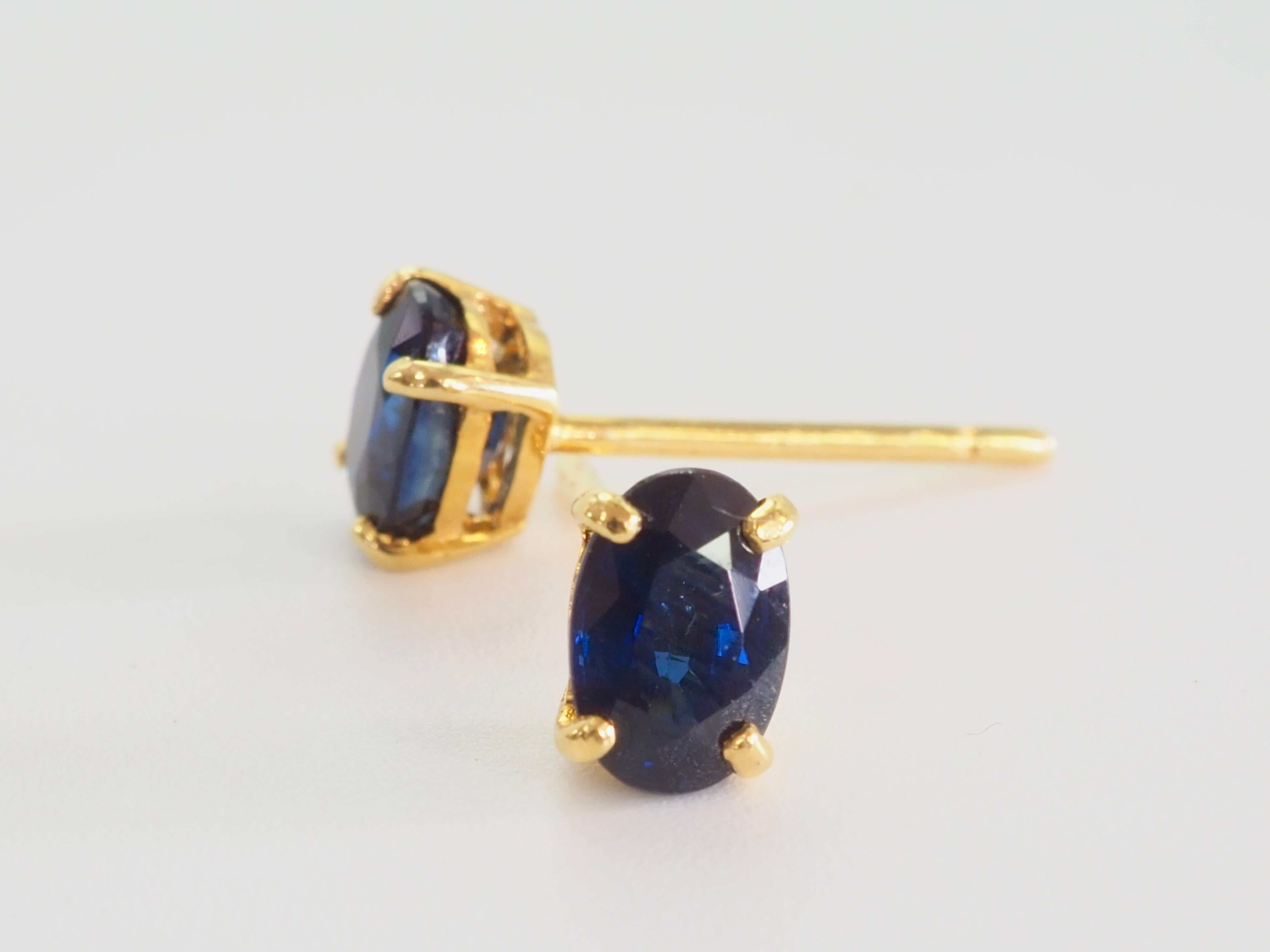 Un paio di intramontabili orecchini a perno con zaffiro tailandese dal taglio ovale, incastonati in un ricco oro giallo 18 carati. Ogni orecchino presenta uno zaffiro blu intenso, per un totale di circa 1,40 carati, sapientemente sfaccettato per