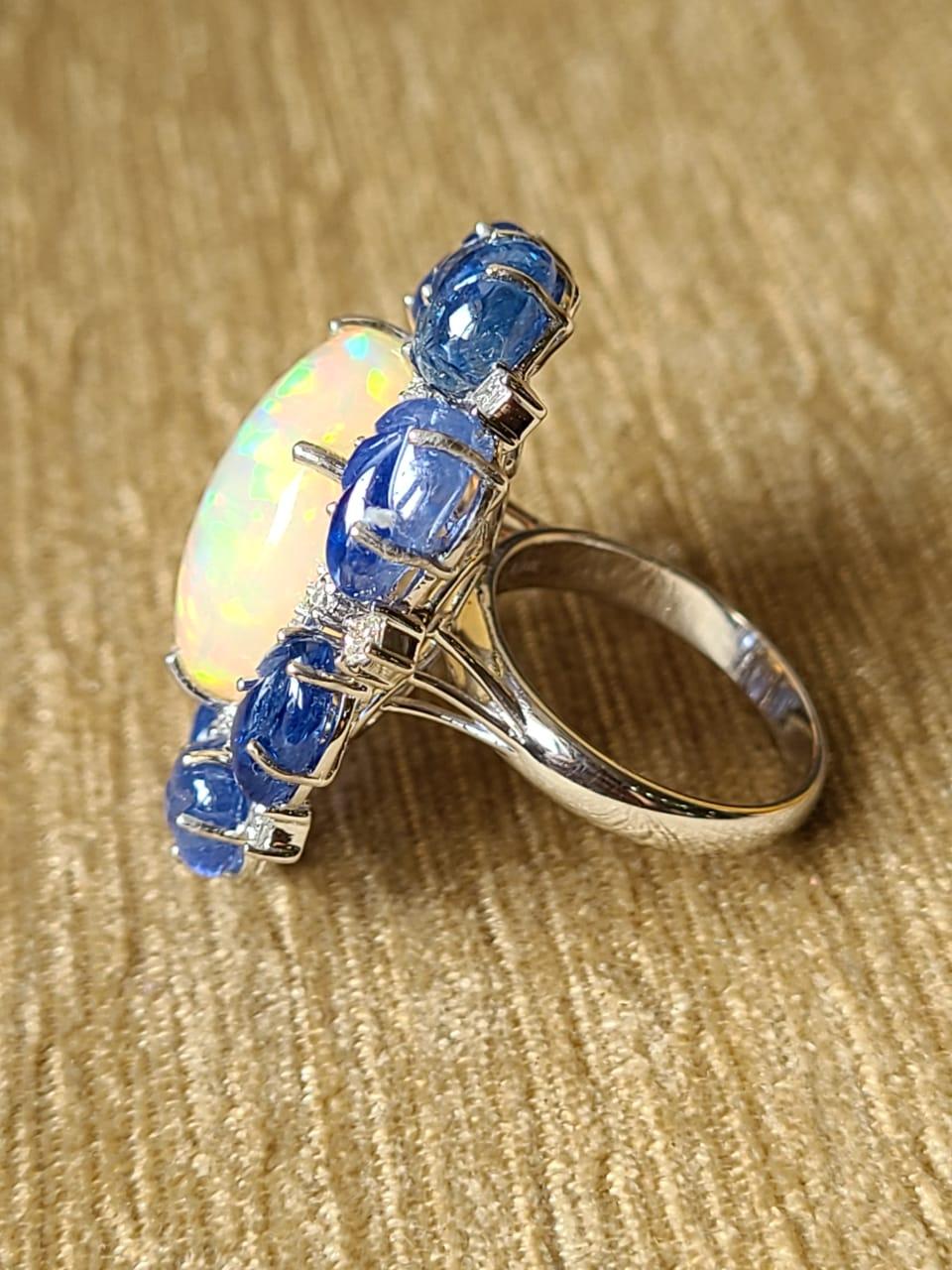 A very gorgeous and one of a kind, Ethiopian Opal & Blue Sapphire Cocktail Ring set in 18K White Gold. The weight of the Opal is 14.68 carats. The Opal is completely natural, without any treatment and is of Ethiopian origin. The weight of the Blue