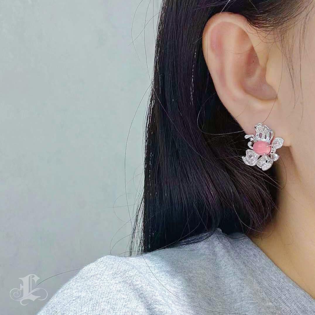 A poetic celebration of natural beauty and graceful form, these Empress Flame Papillon Earrings center around two exquisite natural Conch Pearls totaling 4.65 carats. Displaying a rare Flamingo Pink hue with delicate flame patterns, each pearl is