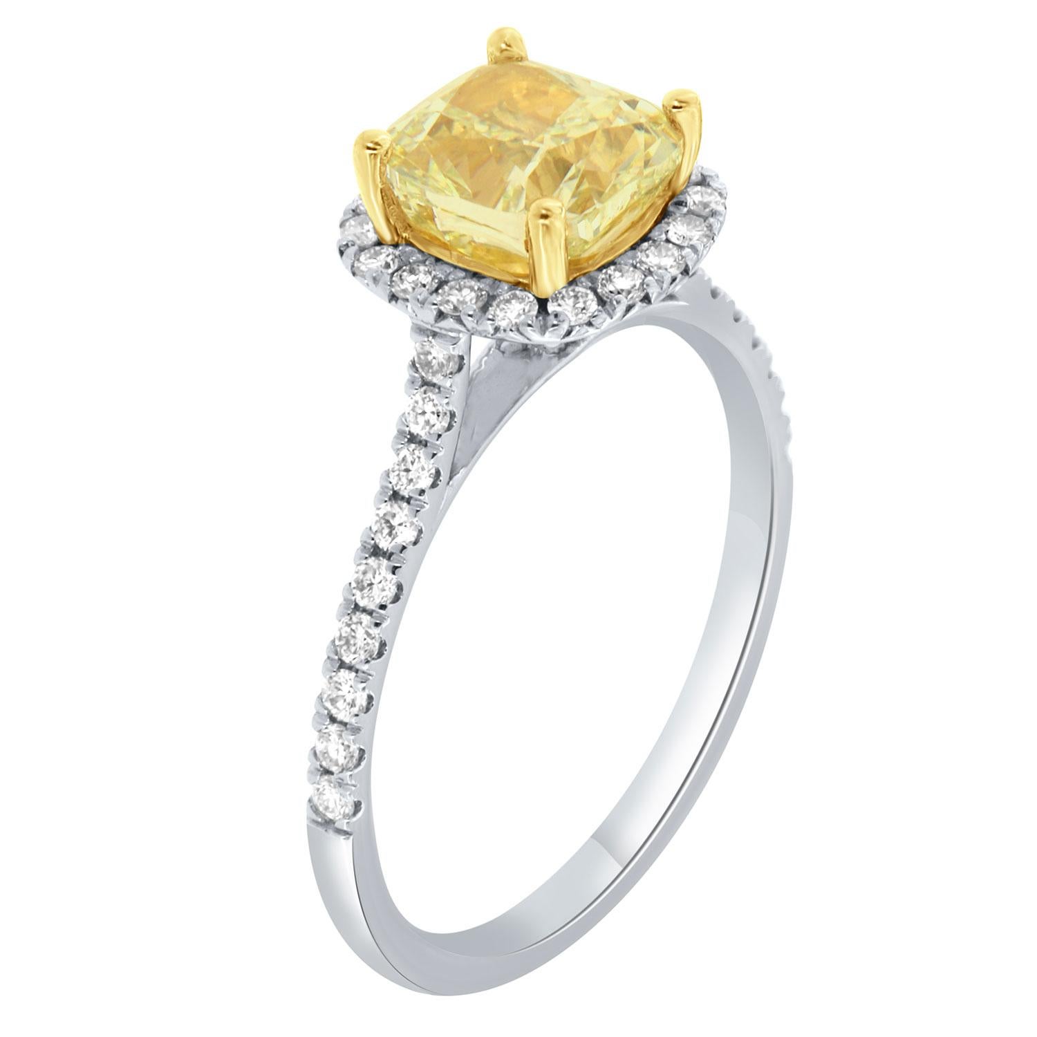 This 18K White and Yellow gold ring feature a 1.60-Carat cushion-shaped Yellow diamond. A halo of brilliant round diamonds encircles the center yellow diamond. One row of diamonds Micro-Prong set underneath the halo on the yellow gold cup completes