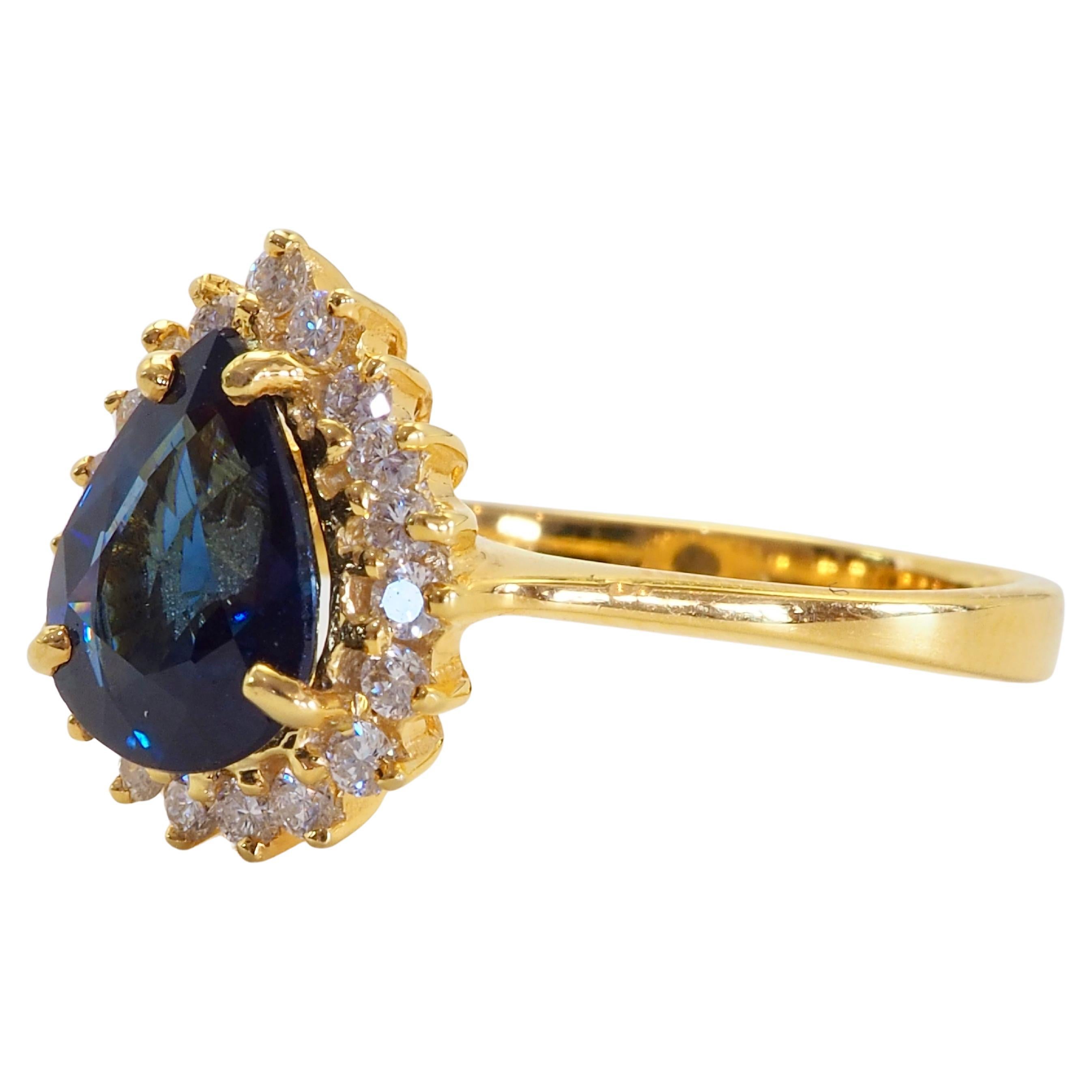 Rare saphir bleu poire thaïlandais provenant des mines de Chanthaburi avec une taille de face décente. De beaux diamants ronds et brillants entourent la pierre précieuse. La tige de style italien est synonyme d'élégance et de