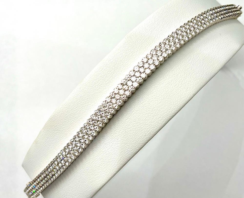 This is a unique Bracelet comprised of 224 Natural White Diamonds with a carat total weight of 18Ct.  Each one of these diamonds is invisibly set and when complete forms three rows. 
In an invisible setting each diamond has a small groove that