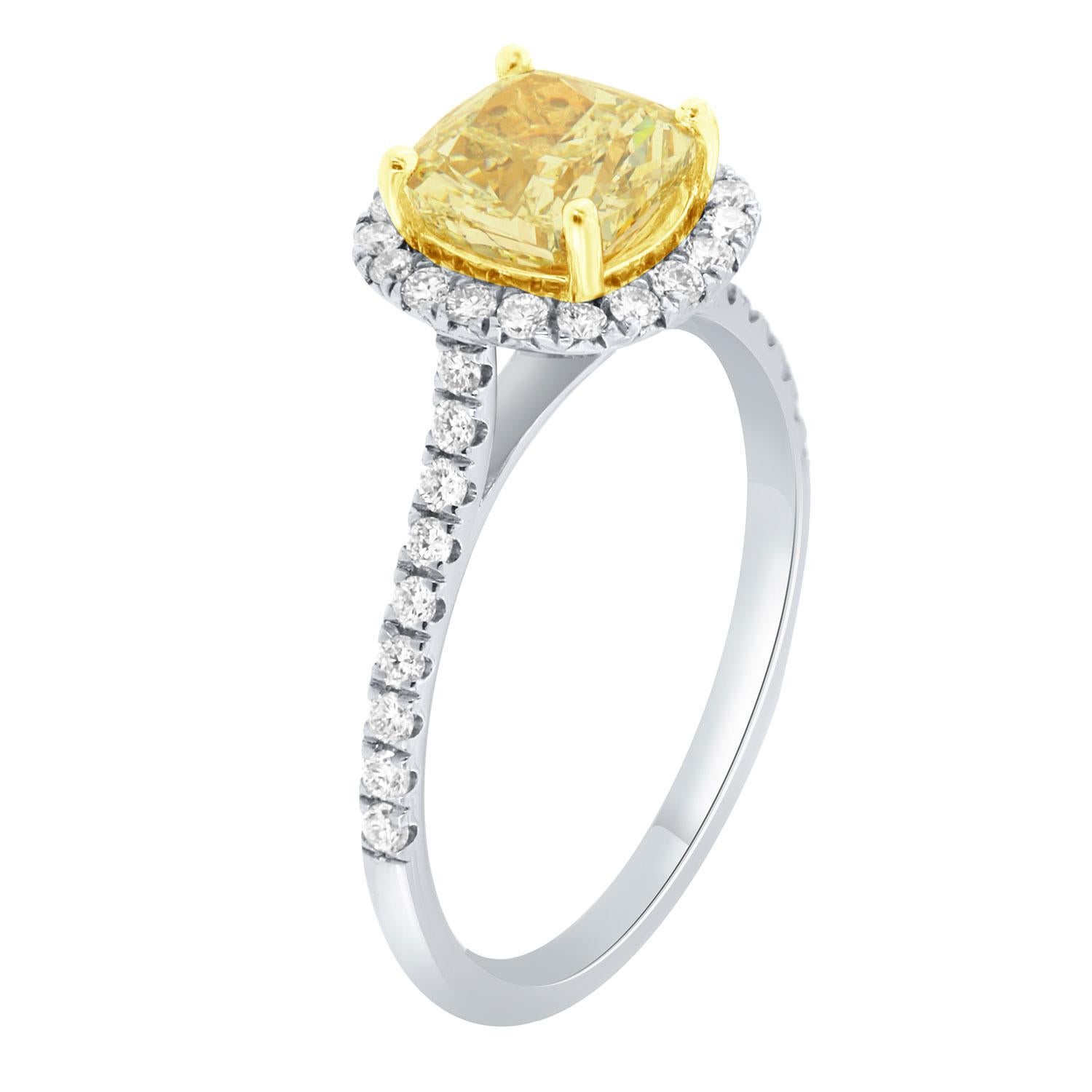 Cette bague en or blanc et jaune 18 carats est ornée d'un diamant jaune de 1,95 carat en forme de coussin. Un halo de diamants ronds brillants entoure le diamant central. L'anneau mesure 1,6 mm de large et contient une rangée de diamants sertis en