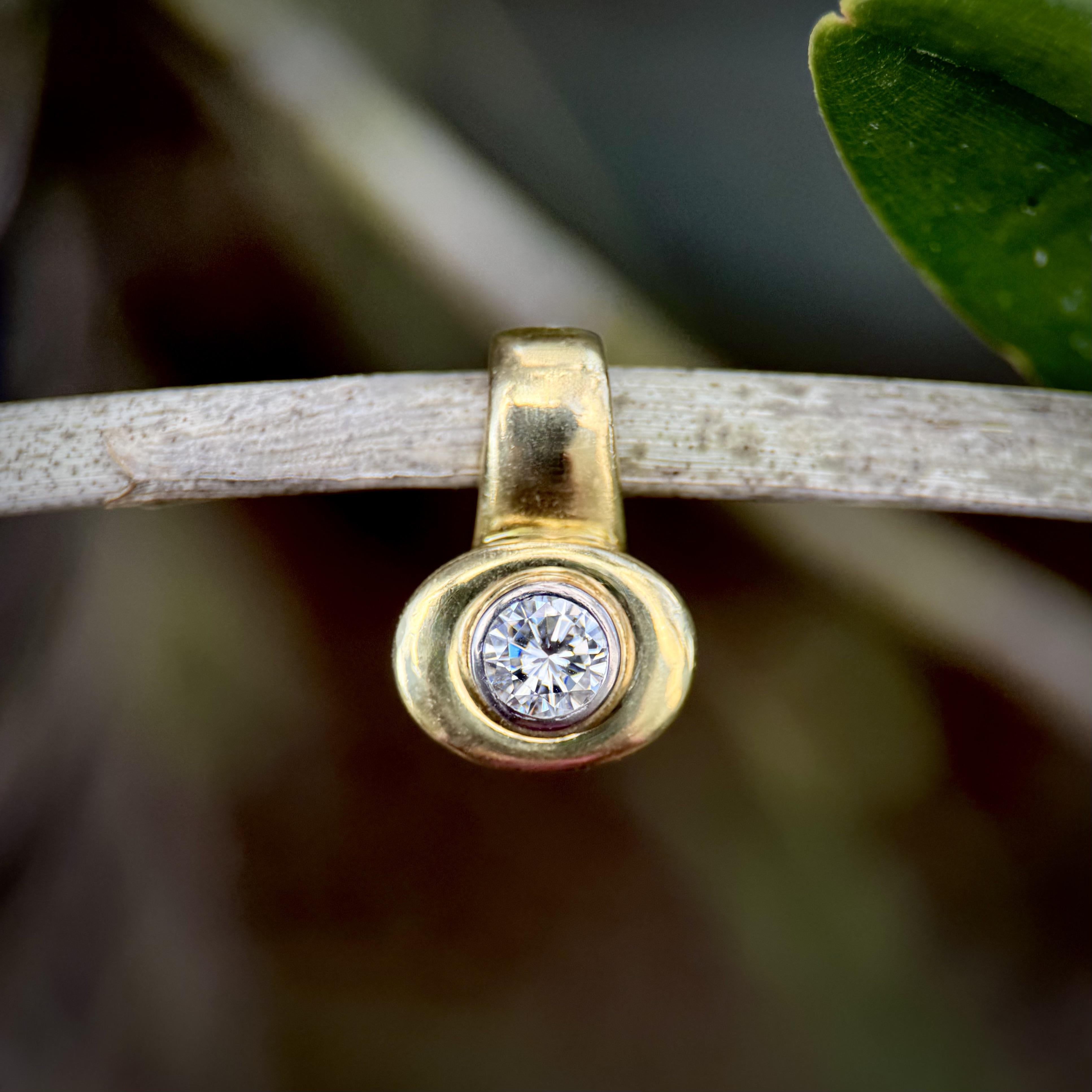 Risalente agli anni '80, questo ciondolo in oro 18 carati ha una forma audace con una cauzione incorporata nel design del pezzo. Un diamante rotondo brillante da un carato è incastonato al centro del pezzo, incorniciato da un grande pendente ovale
