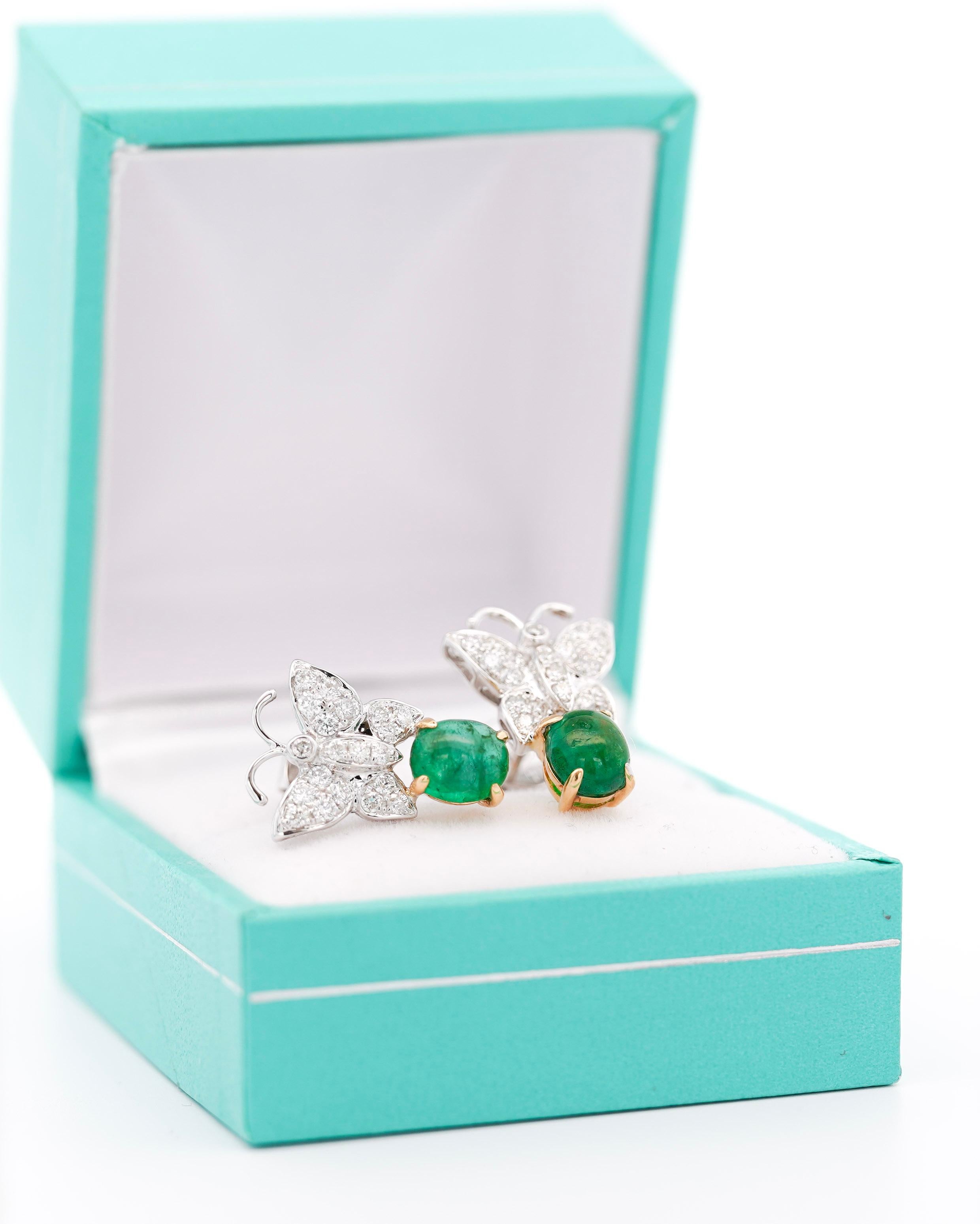 Breathtaking Natural Green Emerald and Diamond Butterfly Motif Drop Earrings, set in 18K White Gold.

The earrings feature 2 cabochon-cut emeralds in a prong setting of over 2 carats. Bearing a bright green color and excellent vibrancy. The diamond