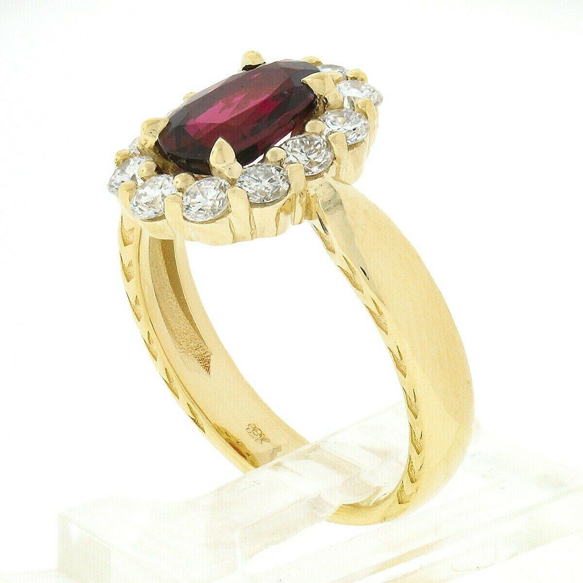 This elegant brand new ruby and diamond halo ring is crafted in solid 18k yellow gold and features a GIA certified natural ruby stone weighing exactly 1.40 carats and displaying a truly rich blood red color. The ruby has a beautiful and unique