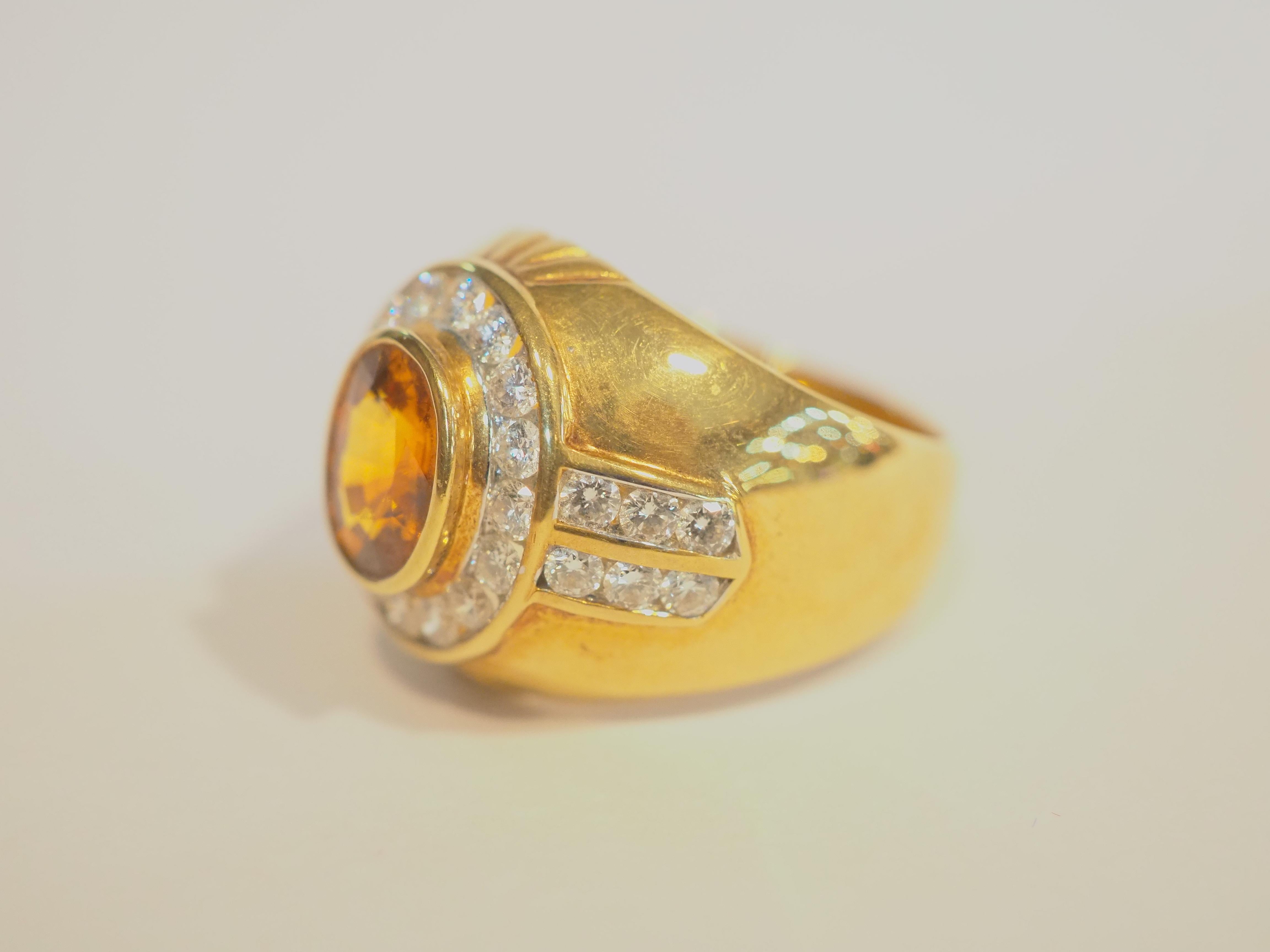  This fantastic cocktail piece is a beautiful 18K yellow gold fine Trombino dome ring for man. It features an oval orangish yellow sapphire as the main gemstone. The color is very saturated, and the surface is very clear. In Thai, this color is