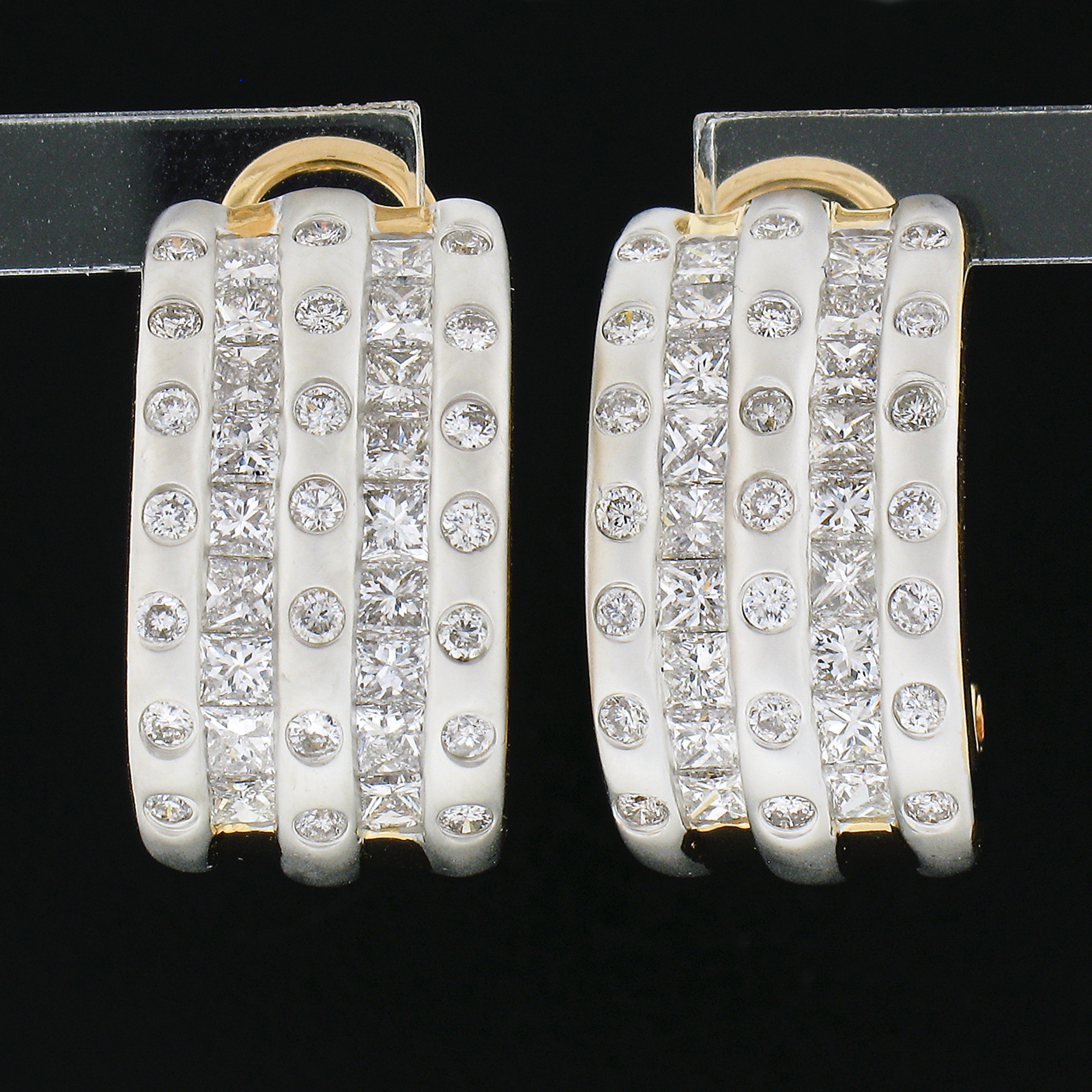 This most wonderful and super elegant pair of earrings are crafted in solid 18k yellow and white gold and features five rows of channel and burnish set diamonds throughout across the wide front. Both princess cuts and round brilliant cut diamonds