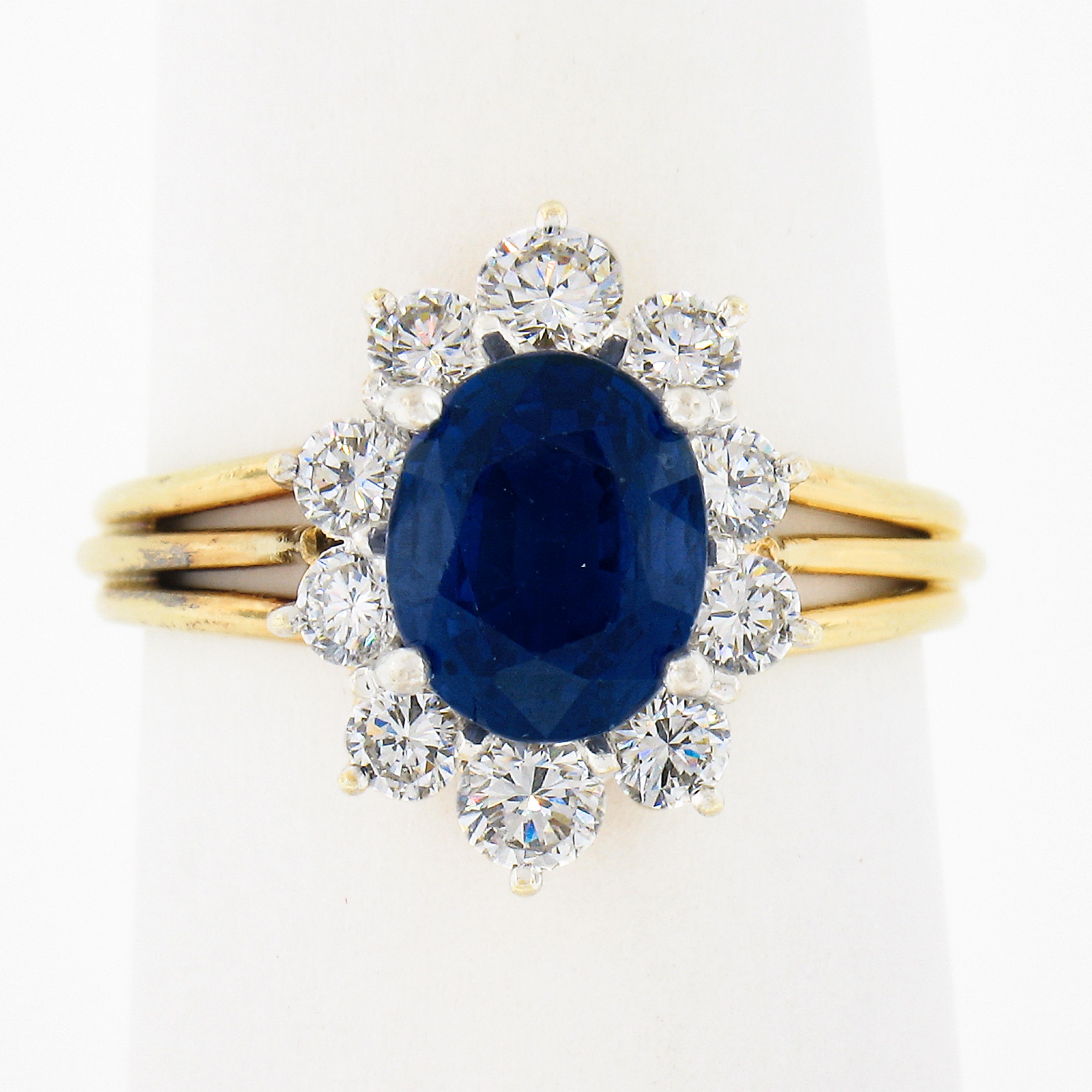 This magnificent sapphire and diamond cocktail ring is crafted in solid 18k gold and features a truly mesmerizing and vibrant oval blue sapphire solitaire at its center which has been certified by GIA as being originated from Burma. Its exceptional