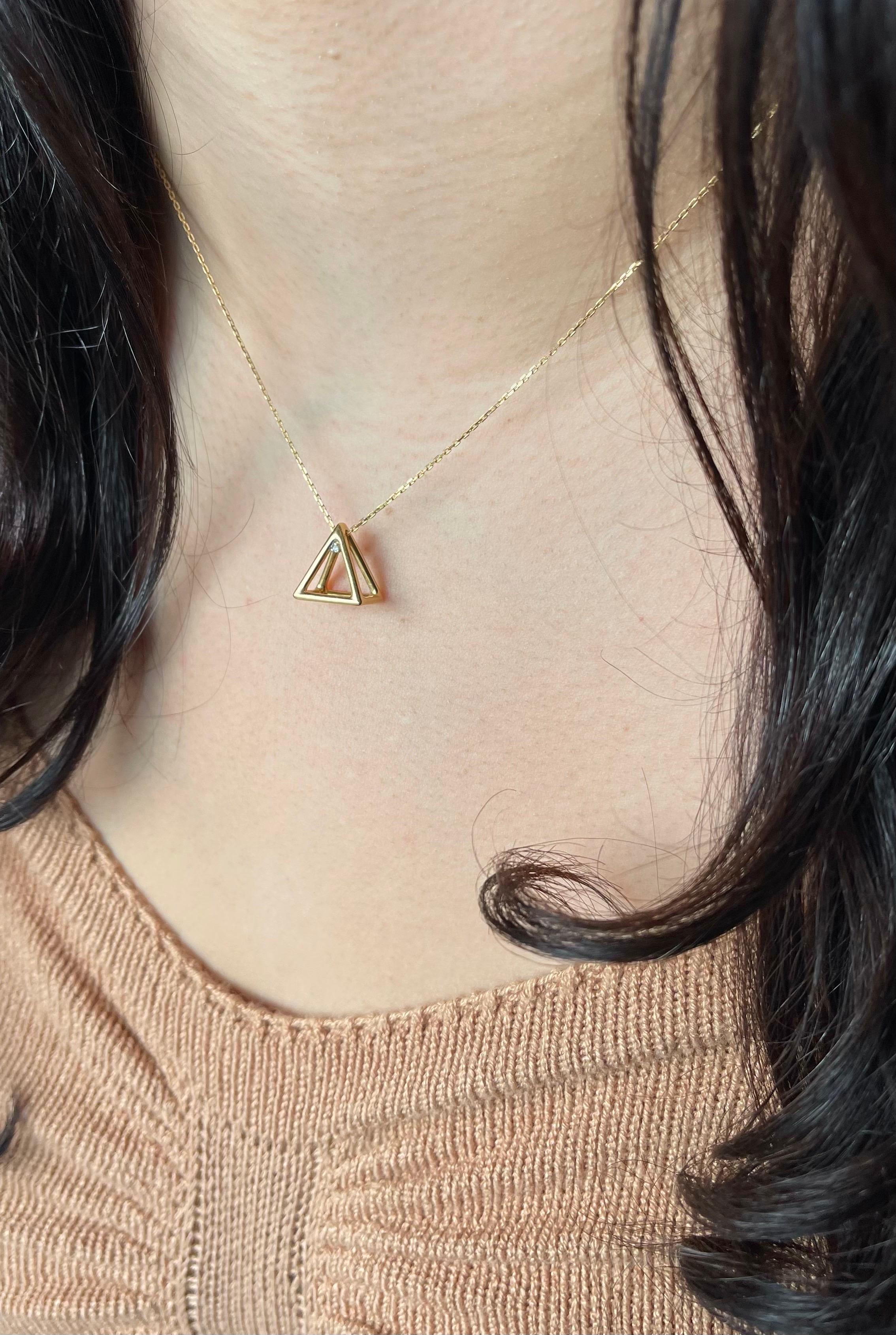 Eleganza e architettura, questo ciondolo a piramide in oro 18 carati è una straordinaria fusione di geometria ed eleganza. La sua silhouette dimensionale e lucidissima cattura la luce da ogni angolazione, offrendo una presenza audace ma minimale