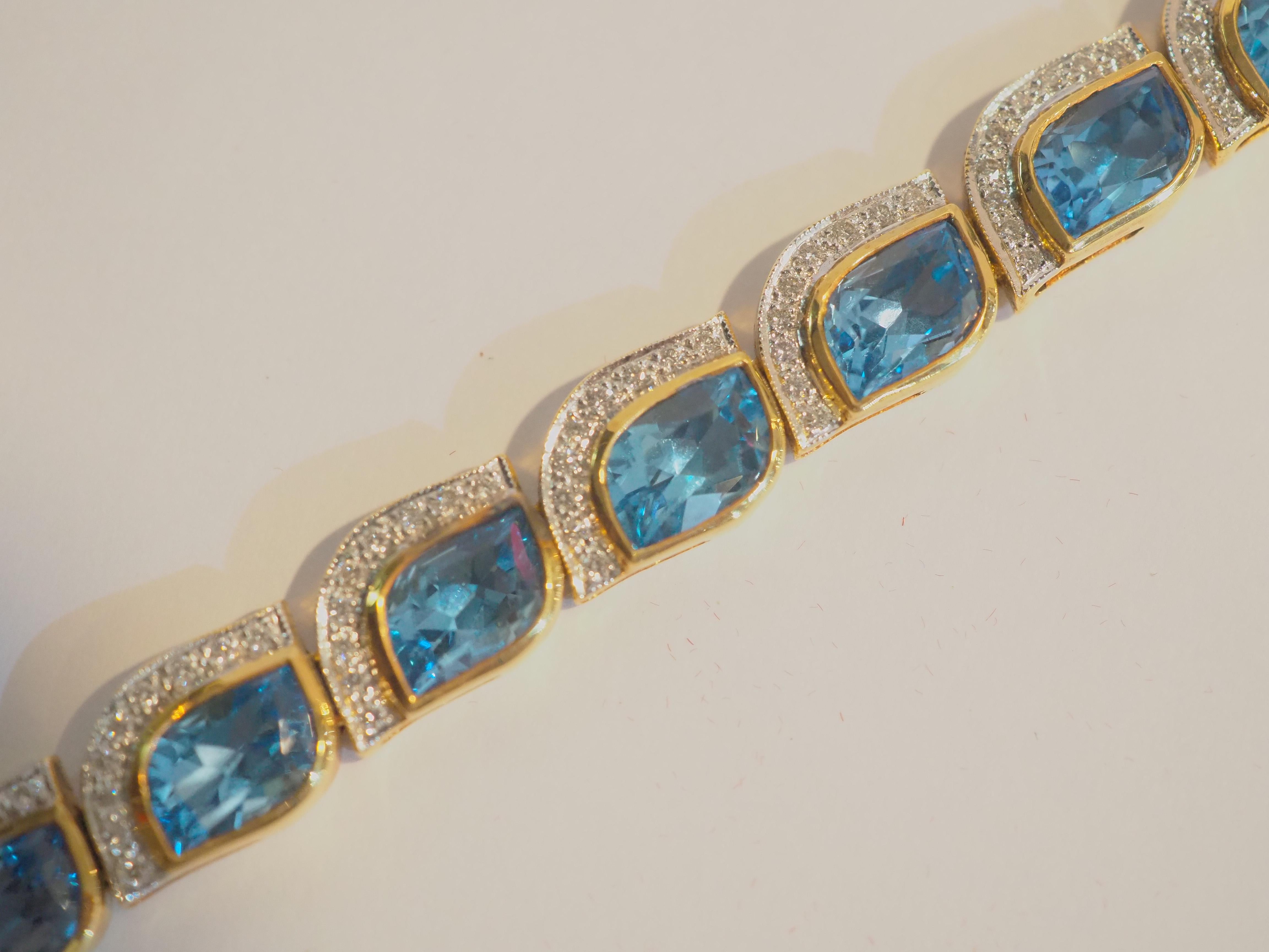A very beautiful and elegant cocktail bracelet in 18K solid yellow gold with 13 natural mixed cut blue topaz with total weight of 30.16 carats and pave diamonds of total 1.41 carats. A very fine bracelet made with immaculate care. The blue topaz is