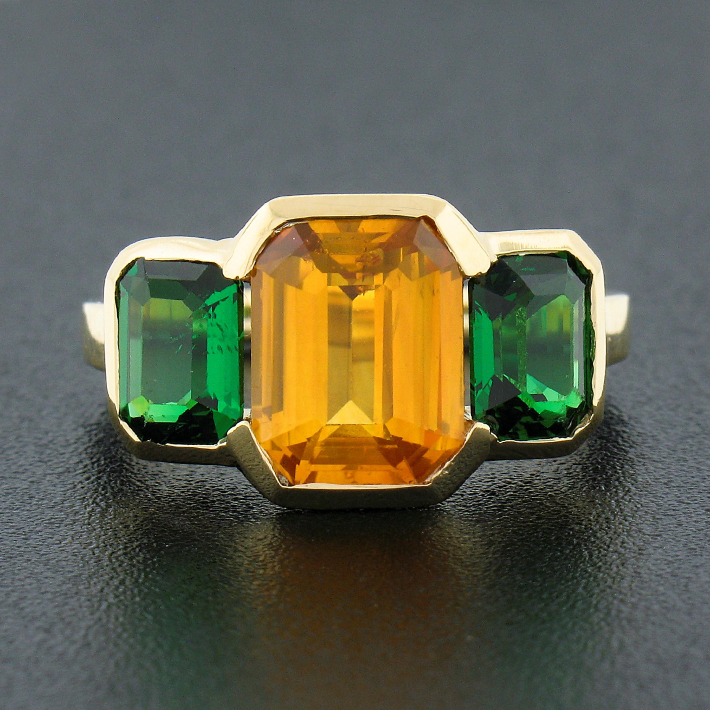 Here we have a fancy and truly magnificent yellow sapphire and green tsavorite cocktail ring crafted in solid 18k yellow gold. The ring features a natural, GIA certified, emerald cut natural yellow sapphire that weighs exactly 3.02 carats and is
