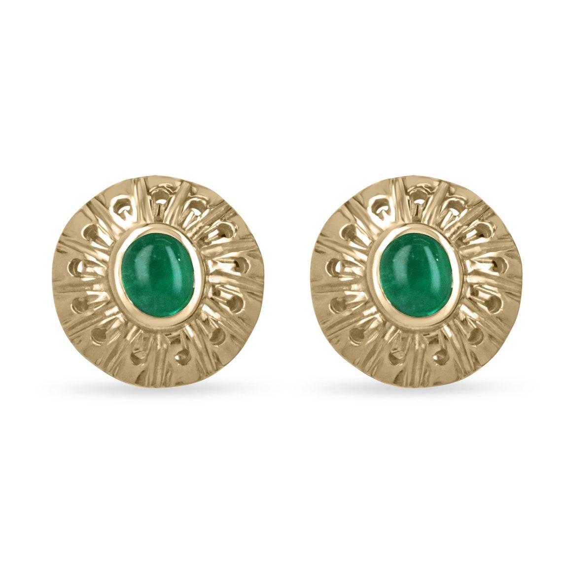 Featured is a gorgeous pair of natural Colombian emerald cabochons hand set in solid 18K yellow gold. The omega-styled earrings welcome a genuine set of Muzo ethically mined cabochon emeralds in a custom-made golden bezel hand-made and hand-carved.