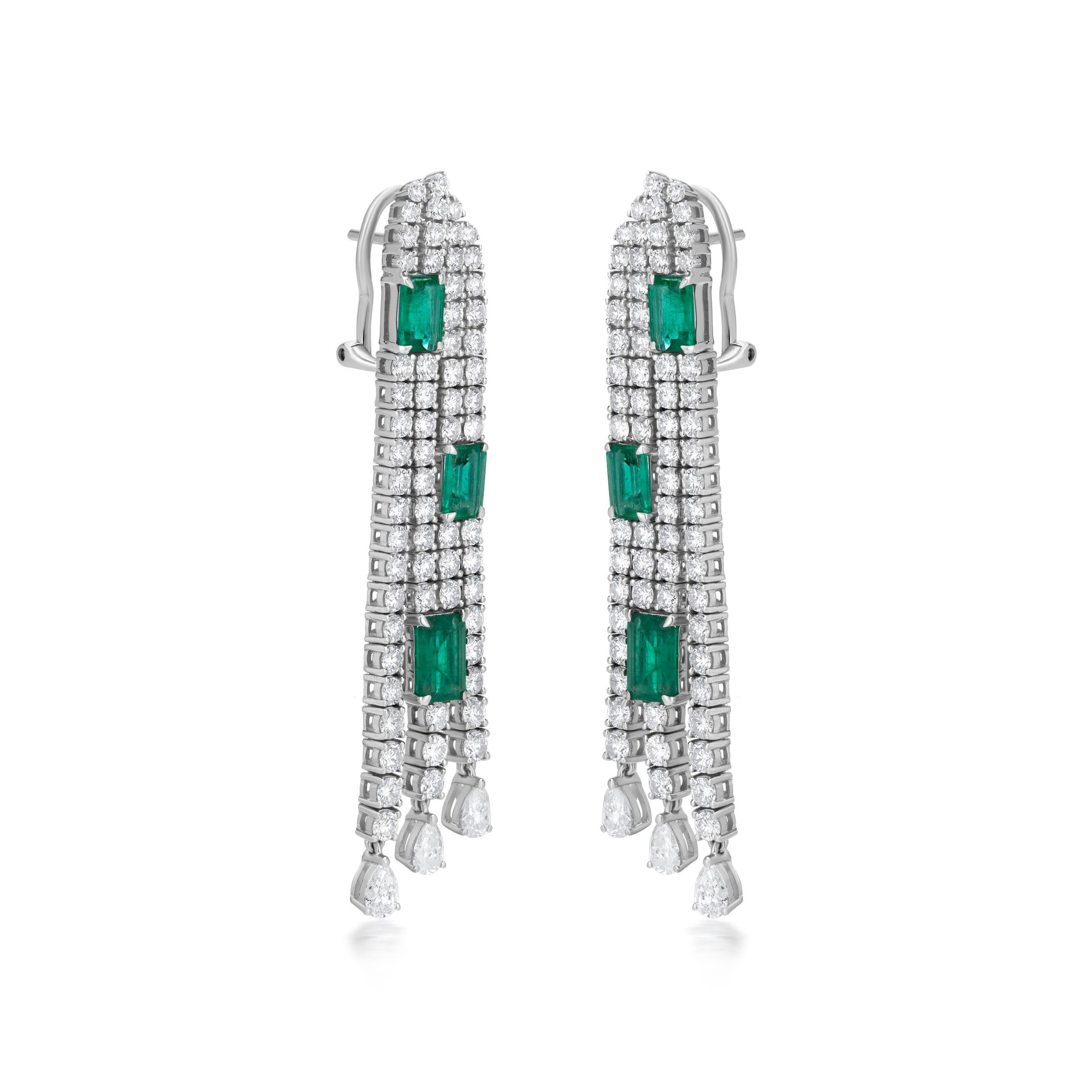 The flowing motif of the dangle earring is accentuated with octagonal emeralds and pear & round-cut diamonds. It looks like a waterfall. The diamond rows of the dangler are clubbed together by octagons of emerald. These octagons of emerald hold the