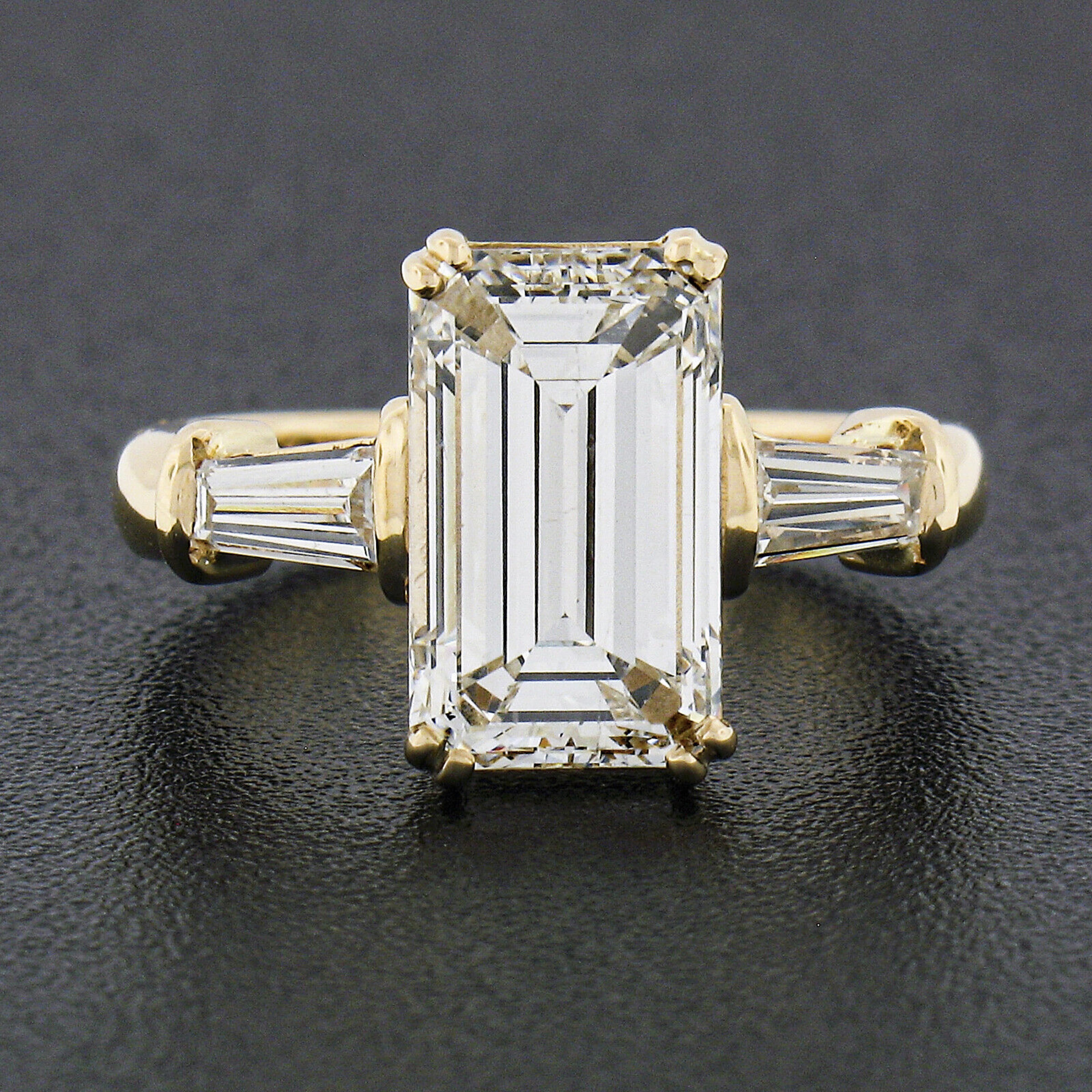You are looking at a truly magnificent and very well made engagement style ring that was crafted from solid 18k yellow. It features an absolutely breathtaking, GIA certified, unique elongated emerald cut diamond solitaire neatly set with dual wire