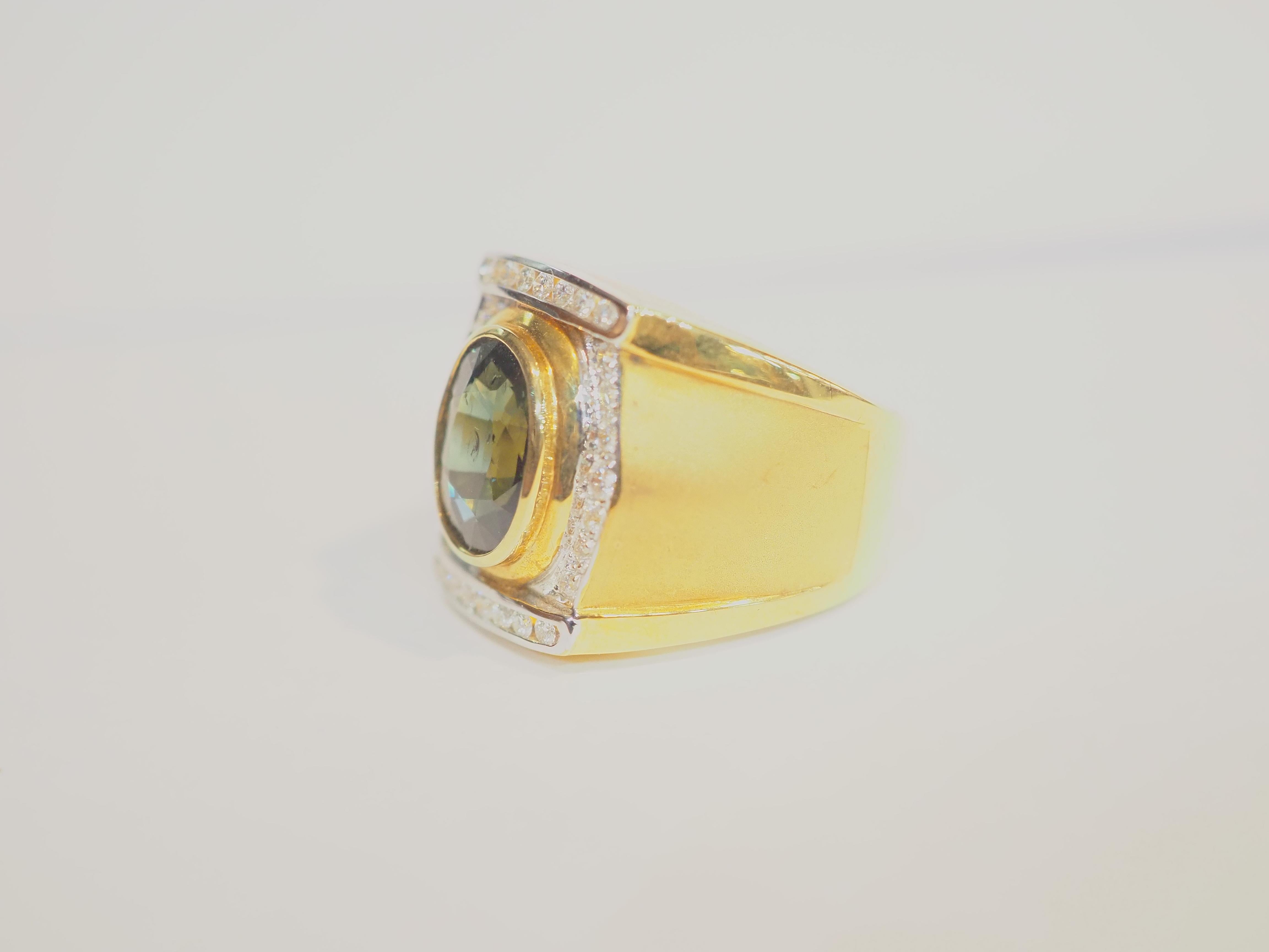  This fantastic cocktail piece is a beautiful 18K yellow gold fine signet ring for man. It features an oval dark teal blue sapphire as the main gemstone. The fire is incredible. There are multiple brilliant diamonds of good color and clarity on the