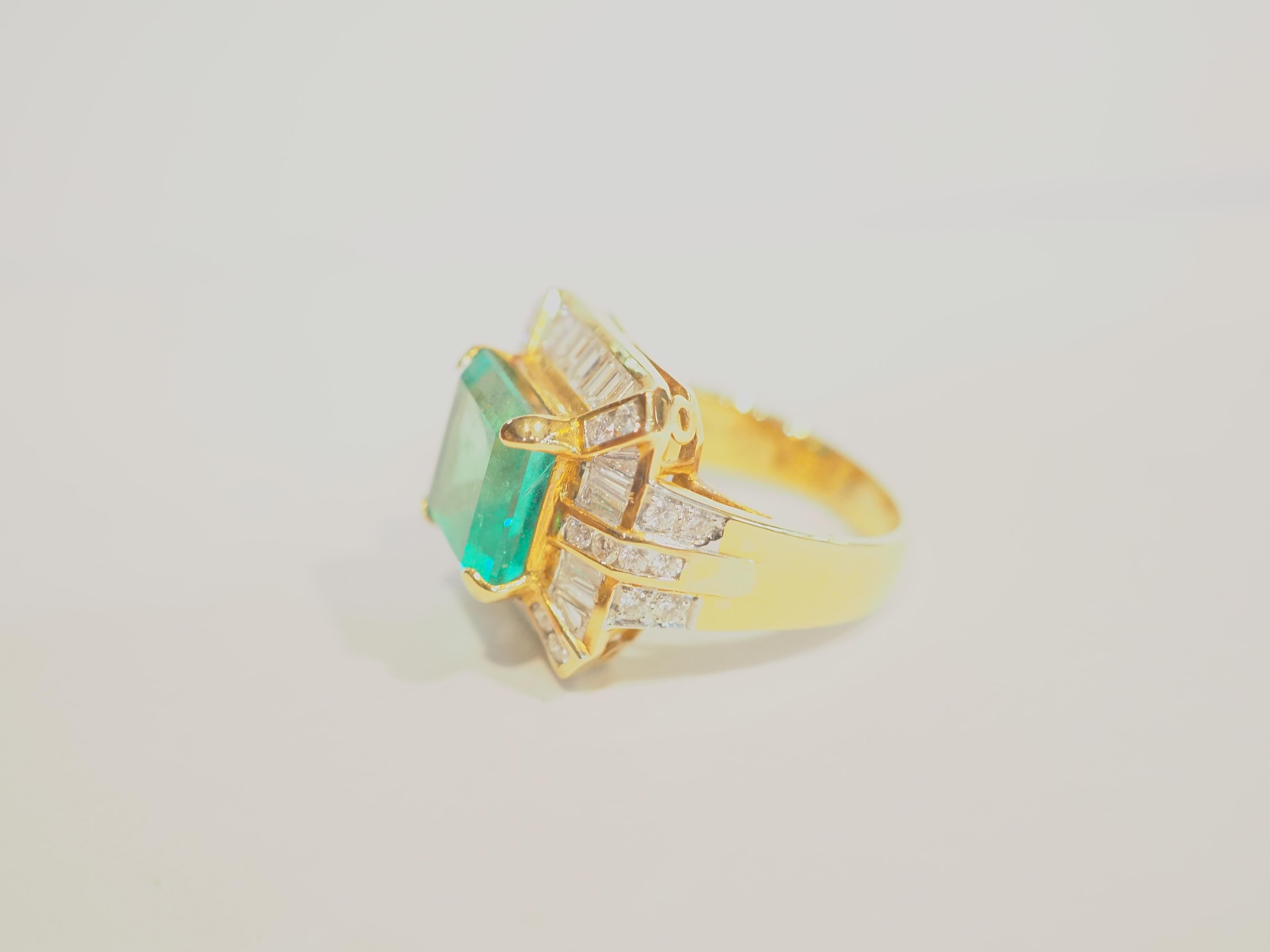  This beautiful cocktail ring boasts a spectacular and good quality emerald cut Colombian emerald! The diamonds are bright and lively and clarity and color all surrounding the beautiful leaf green gemstone. This ring is never worn and kept as like