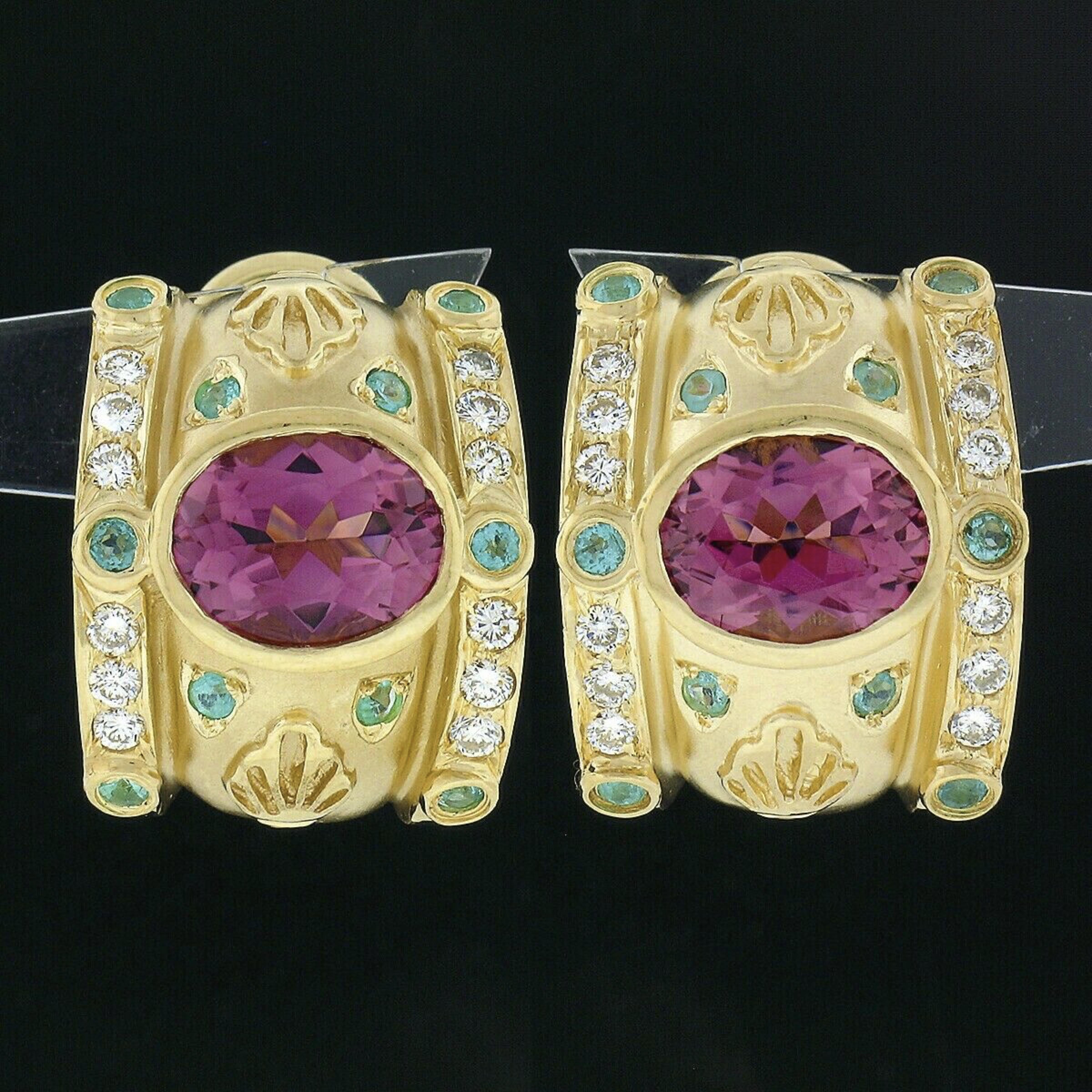 These gorgeous and well made cuff earrings are crafted in solid 18k yellow gold and are set with very fine quality stones throughout their wide and truly elegant design. They each feature an oval brilliant cut pink tourmaline neatly bezel set the