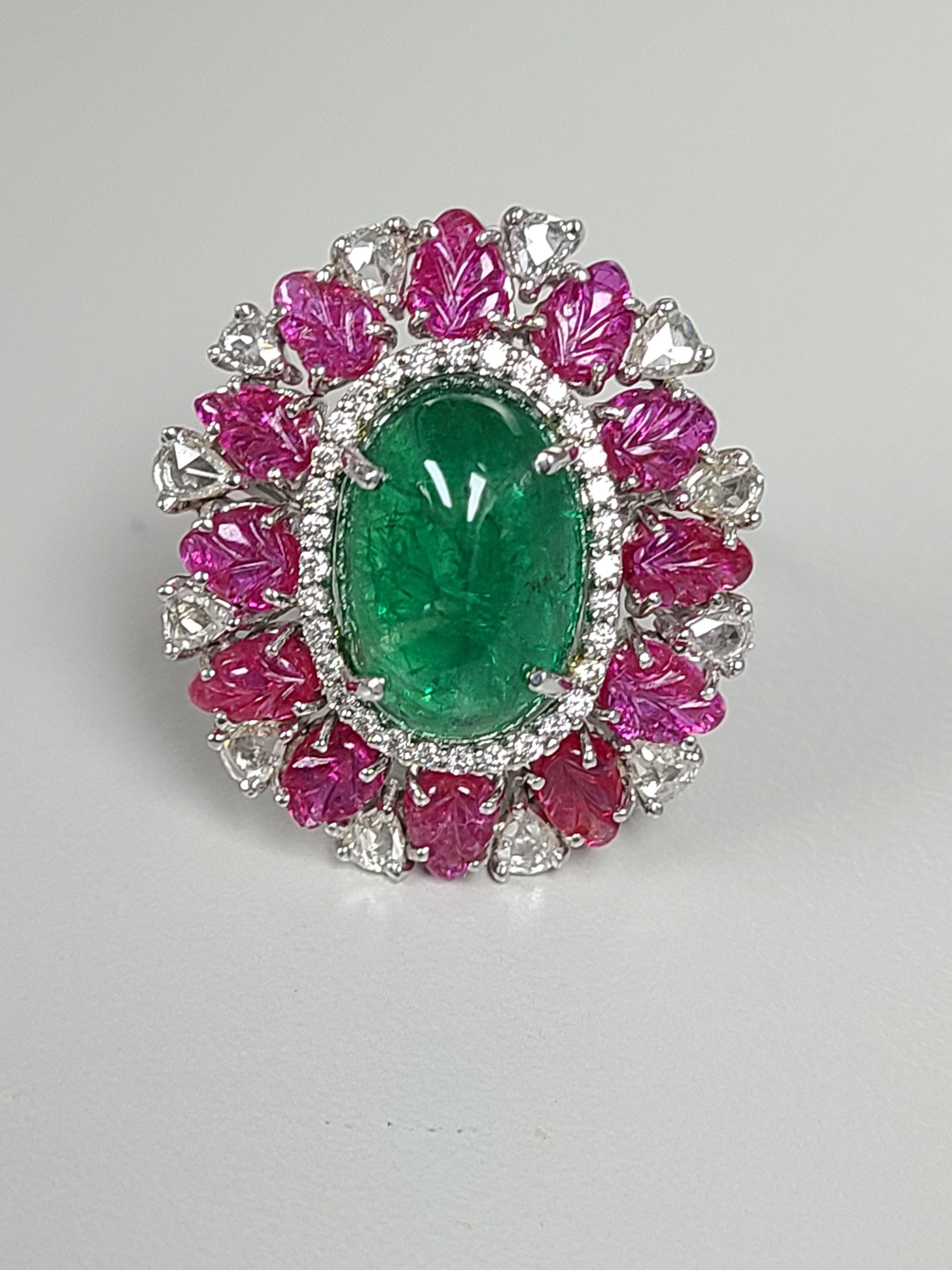 modern and chic ring made in 18k white gold , natural emerald cabochon from zambia weighing 6.82 carats , unheat ruby leaves weighing 3.83 carats and diamonds weighing 1.05 carats . ring dimensions in cm 2.5 x 2 x 3 ( L X W X H)