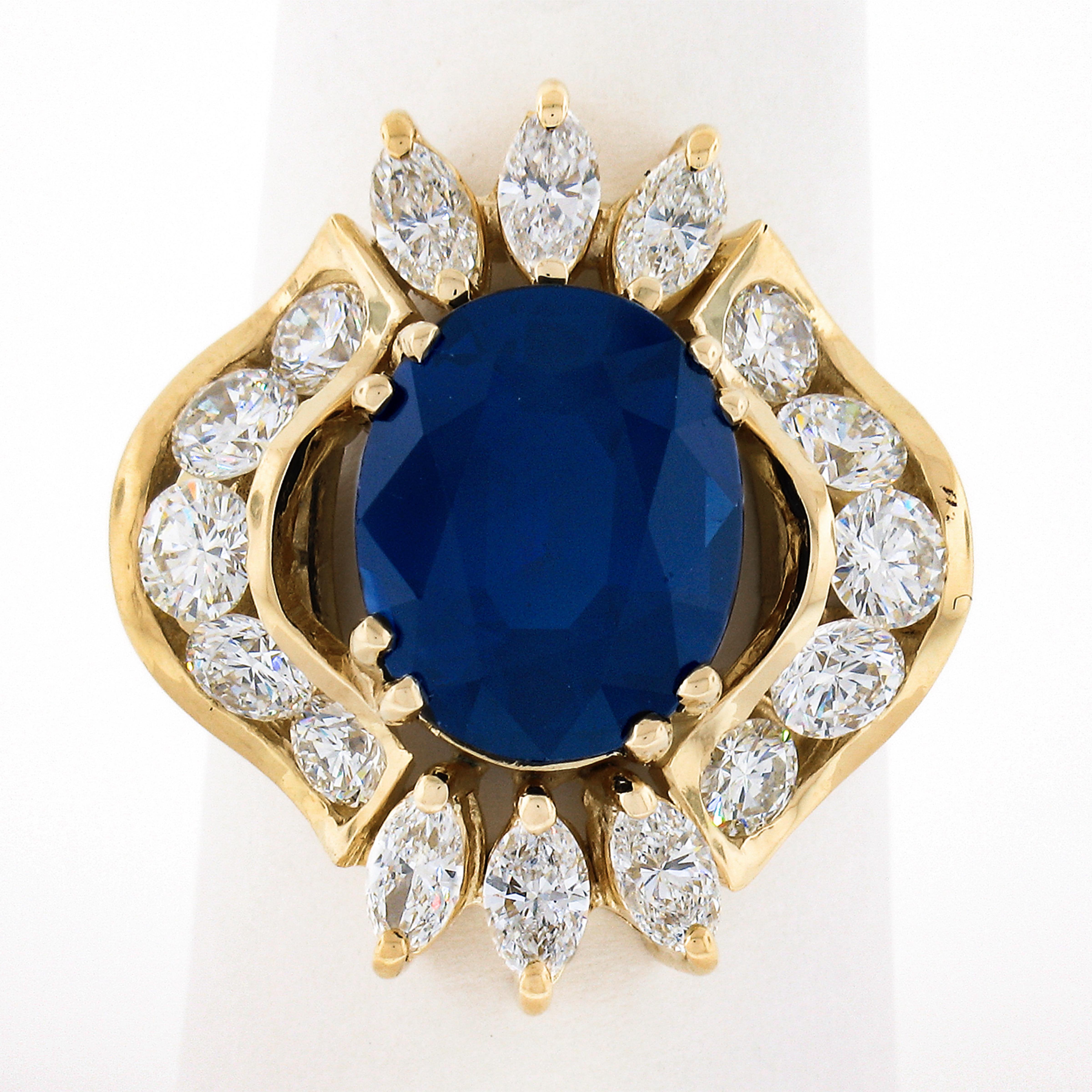 Here we have a truly breathtaking cocktail ring that was crafted from solid 18k yellow gold featuring a GIA certified, natural sapphire stone neatly dual prong set at the center of a fiery diamond drenched wavy design. The oval cut sapphire weighs