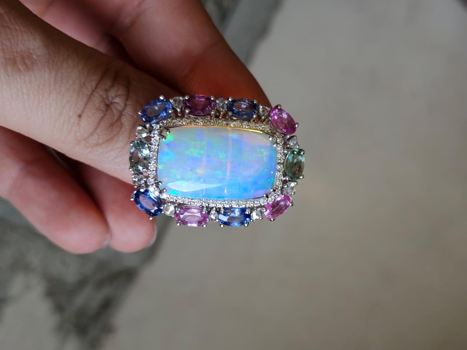 A very gorgeous and beautiful, Ethiopian Opal & Multi Sapphires Cocktail Ring set in 18K White Gold & Diamonds. The weight of the Ethiopian Opal is 8.92 carats. The Opal has a green - blue play of colour. The weight of the Multi Sapphires is 5.78