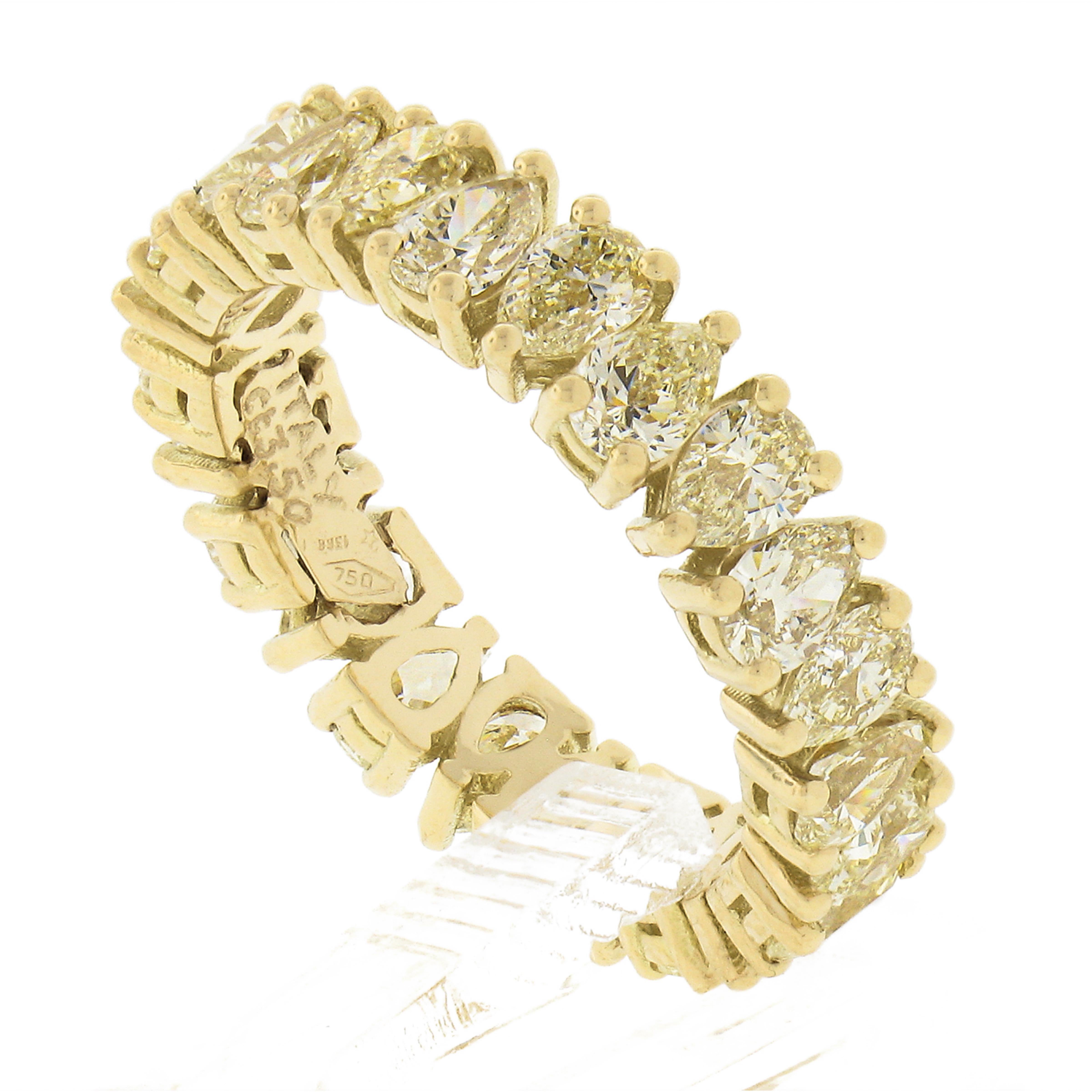 This breathtaking new eternity band ring is crafted in solid 18k yellow gold and features 24 stunning fancy light to fancy yellow color diamond stones which are neatly prong set entirely throughout. The pear brilliant cut diamonds total 3.50 carats