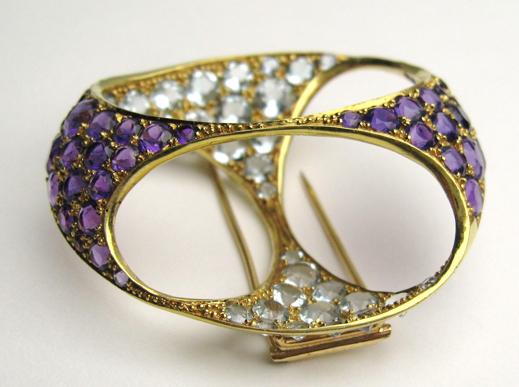 We have a stunning 18K Gold Coat Clip / Brooch adorned with amethysts and aquamarine stones, Approximately 6 carats of Aquamarine and Approximately 6 carats of Amethysts.  Measuring 1.93