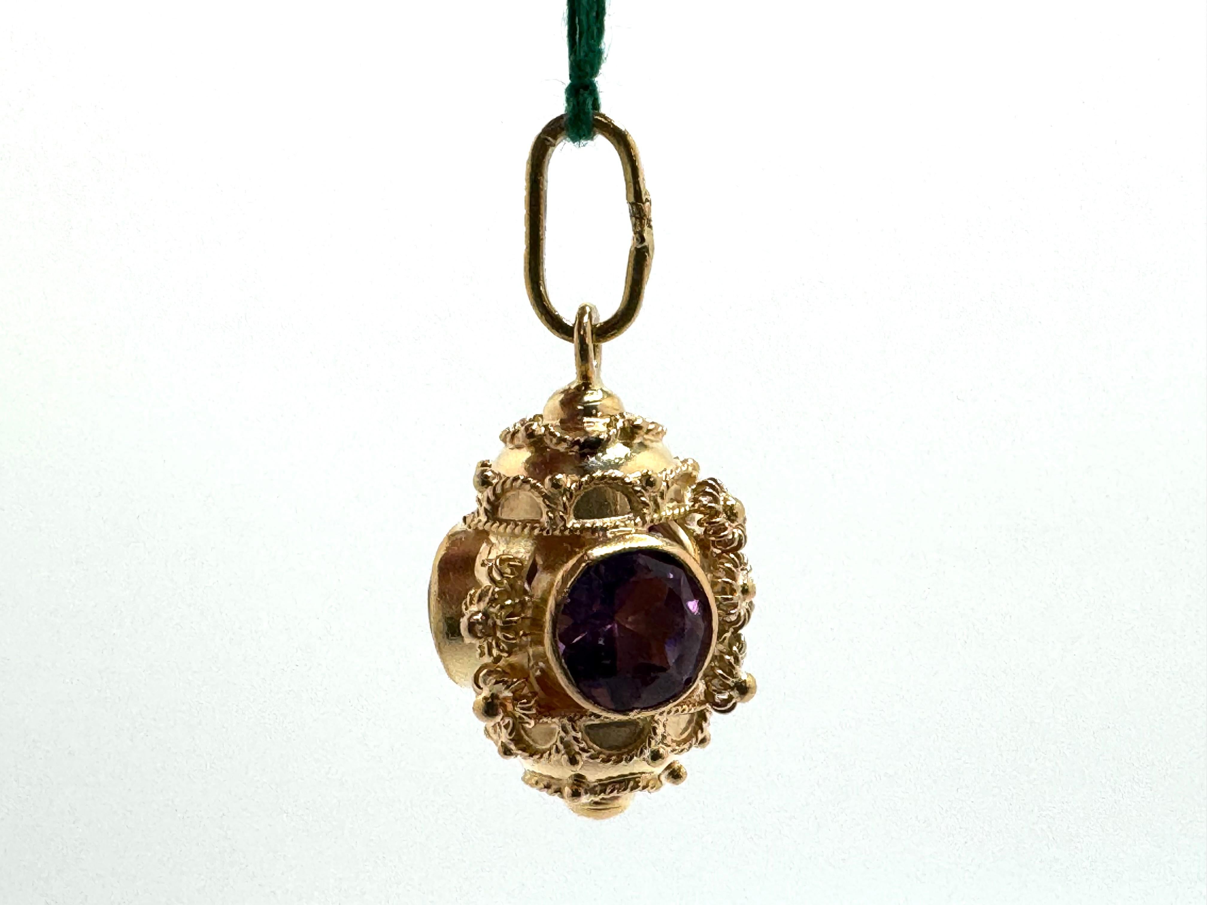 This exquisite pendant is crafted from 18K gold and showcases a rich Etruscan-inspired design. At its center are three vibrant amethyst gemstones, each measuring approximately 6.5mm. The deep purple hues of the amethysts add a luxurious and regal