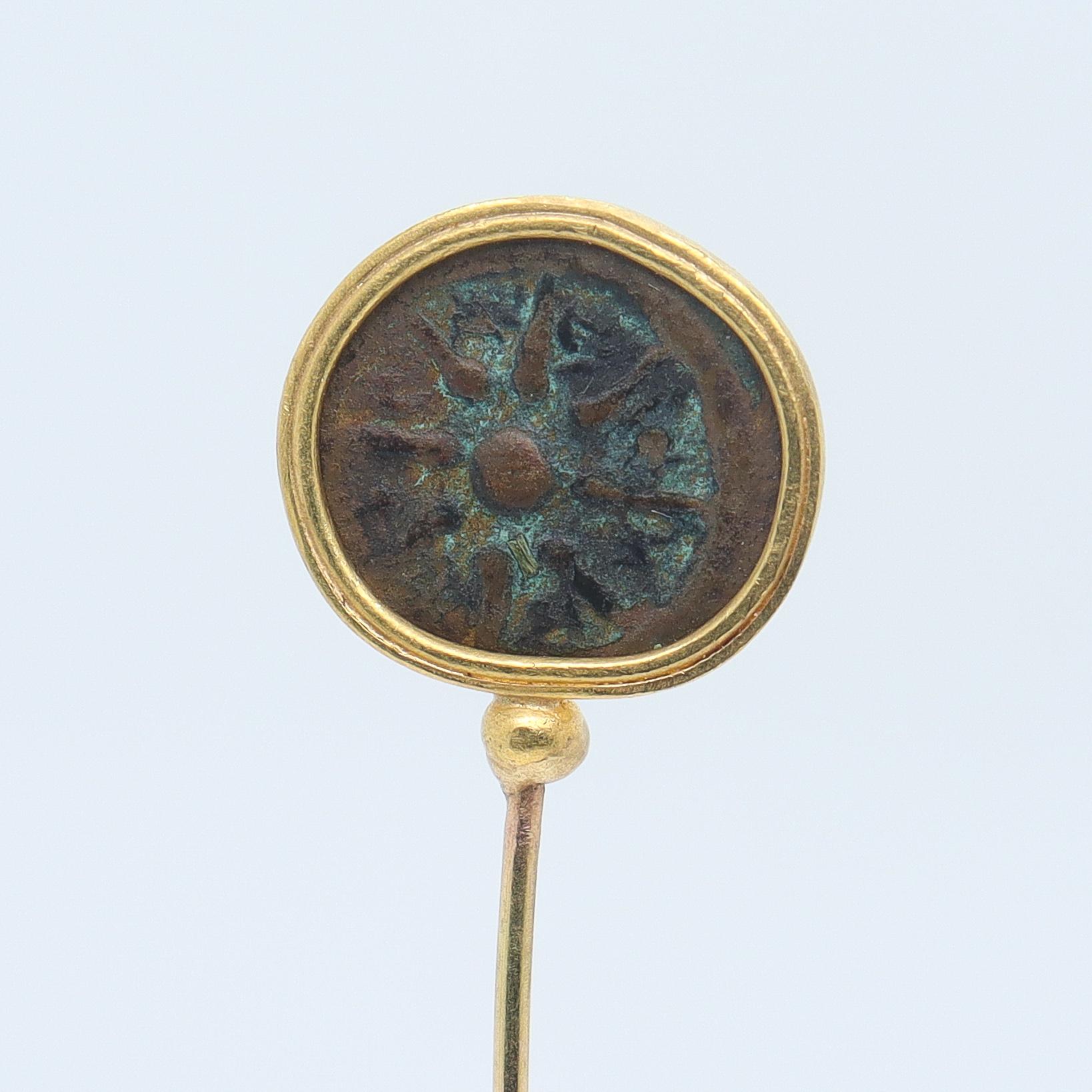 A gold and ancient Roman bronze coin stickpin.

The bronze coin is bezel set in a high karat (18k or higher) gold bezel. 

The pin stem itself is 14k. 

Simply a wonderful piece of the ancient world!

Overall Condition:
It is in overall good,