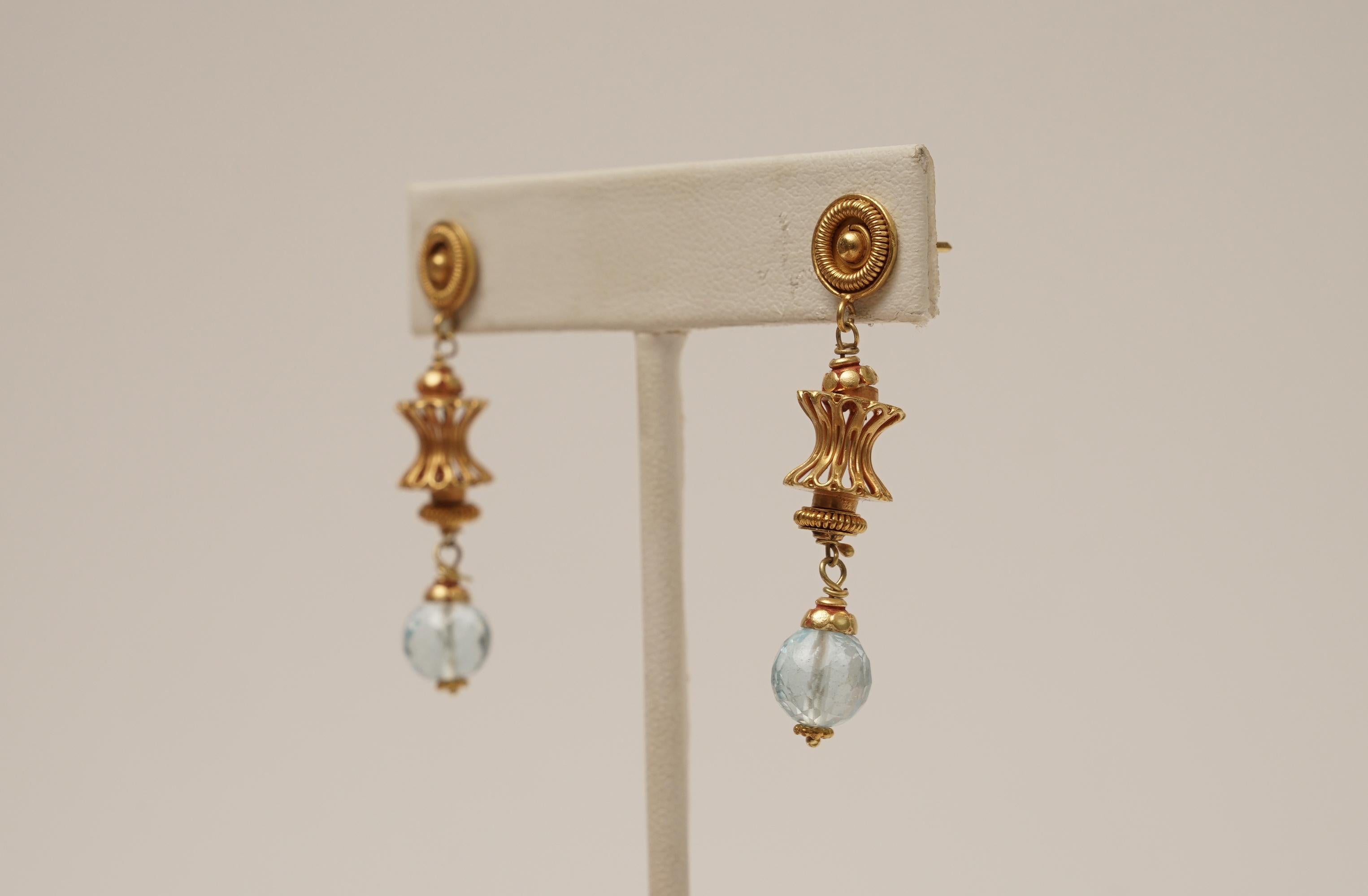 A pair of 18K gold dangle earrings with detailed granulation and wire work with a faceted, round aquamarine drop at the bottom.  18K Gold stud for pierced ears.  By Deborah Lockhart Phillips
